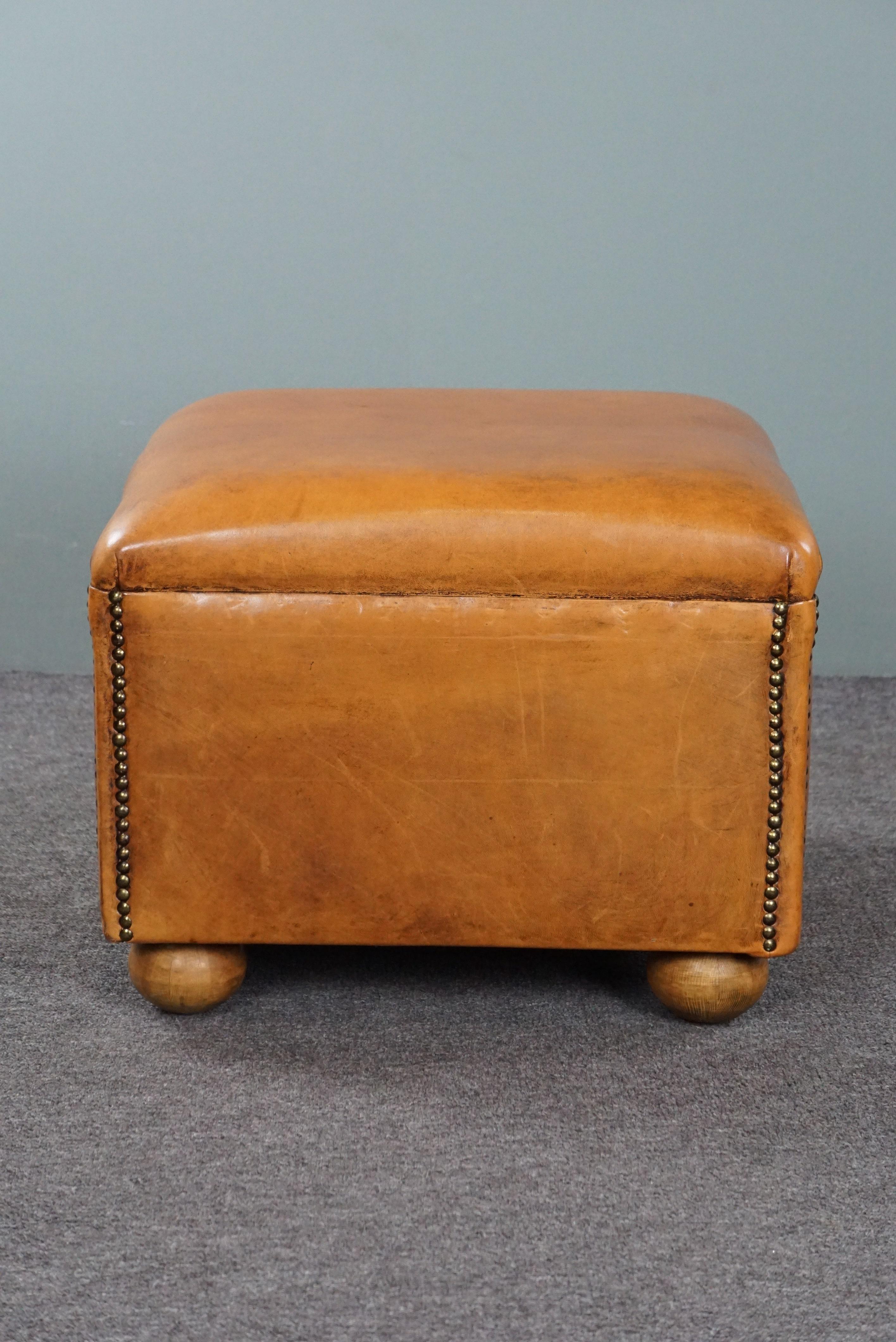 Leather Elegant sheep leather ottoman with spherical legs For Sale