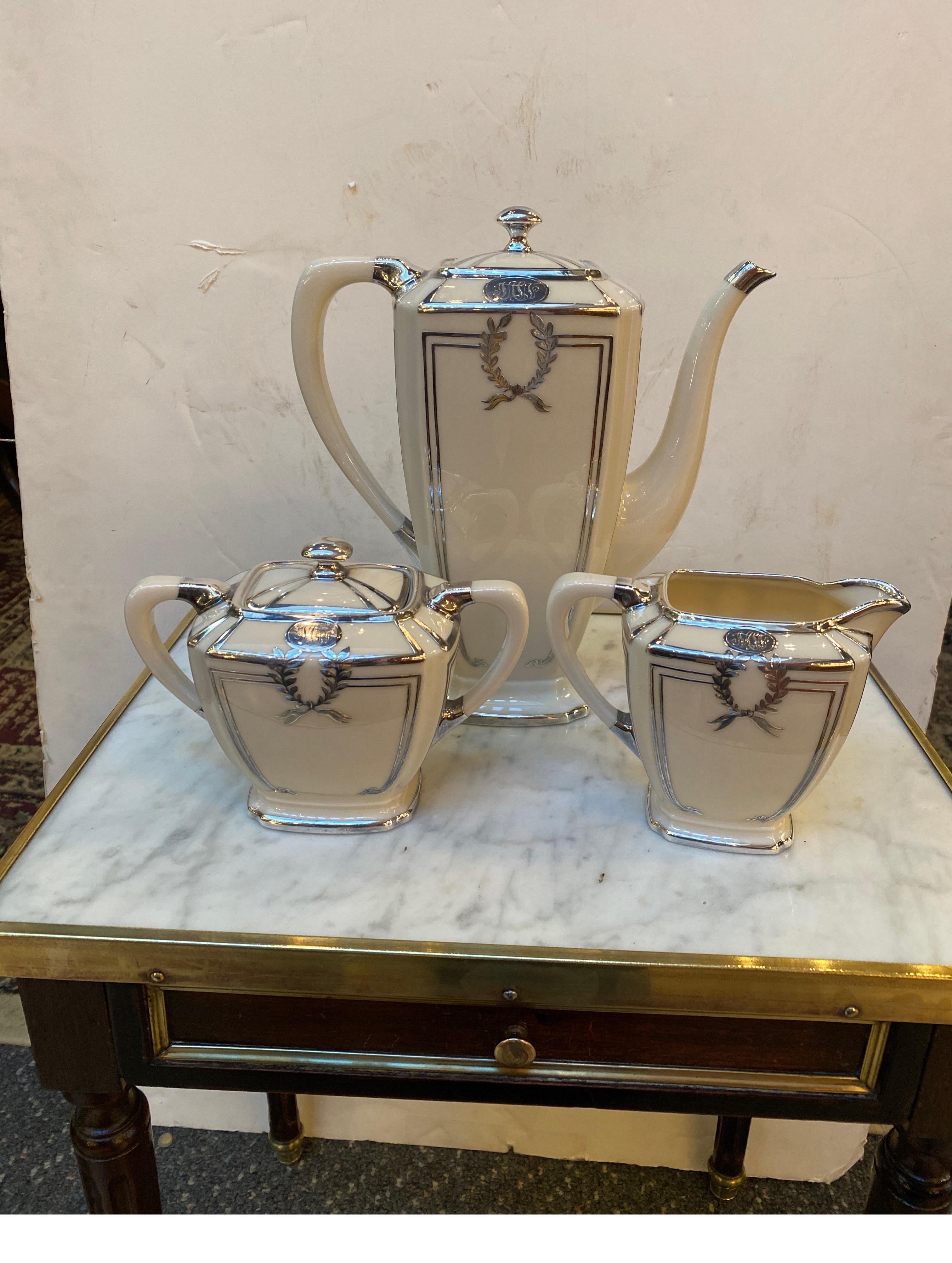 Elegant coffee service with coffeepot, covered sugar and creamer with sterling silver overlay. Made by Lenox Belleek with a green mark on the bottom used from 1896 till 1905.