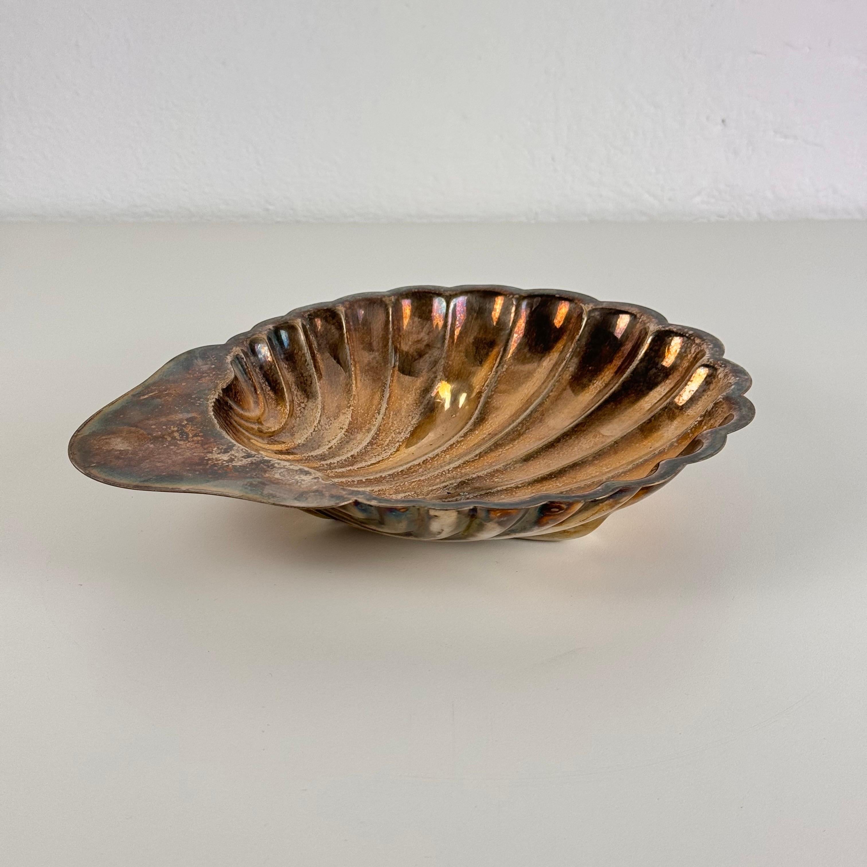 Impresionante ejemplo de la elegancia de mediados de siglo, este exquisito centro de mesa y bandeja en forma de concha está elaborado en plata plateada por Fleuron-Christofle, Francia, y encarna el sofisticado estilo de Gio Ponti. Fabricado en la
