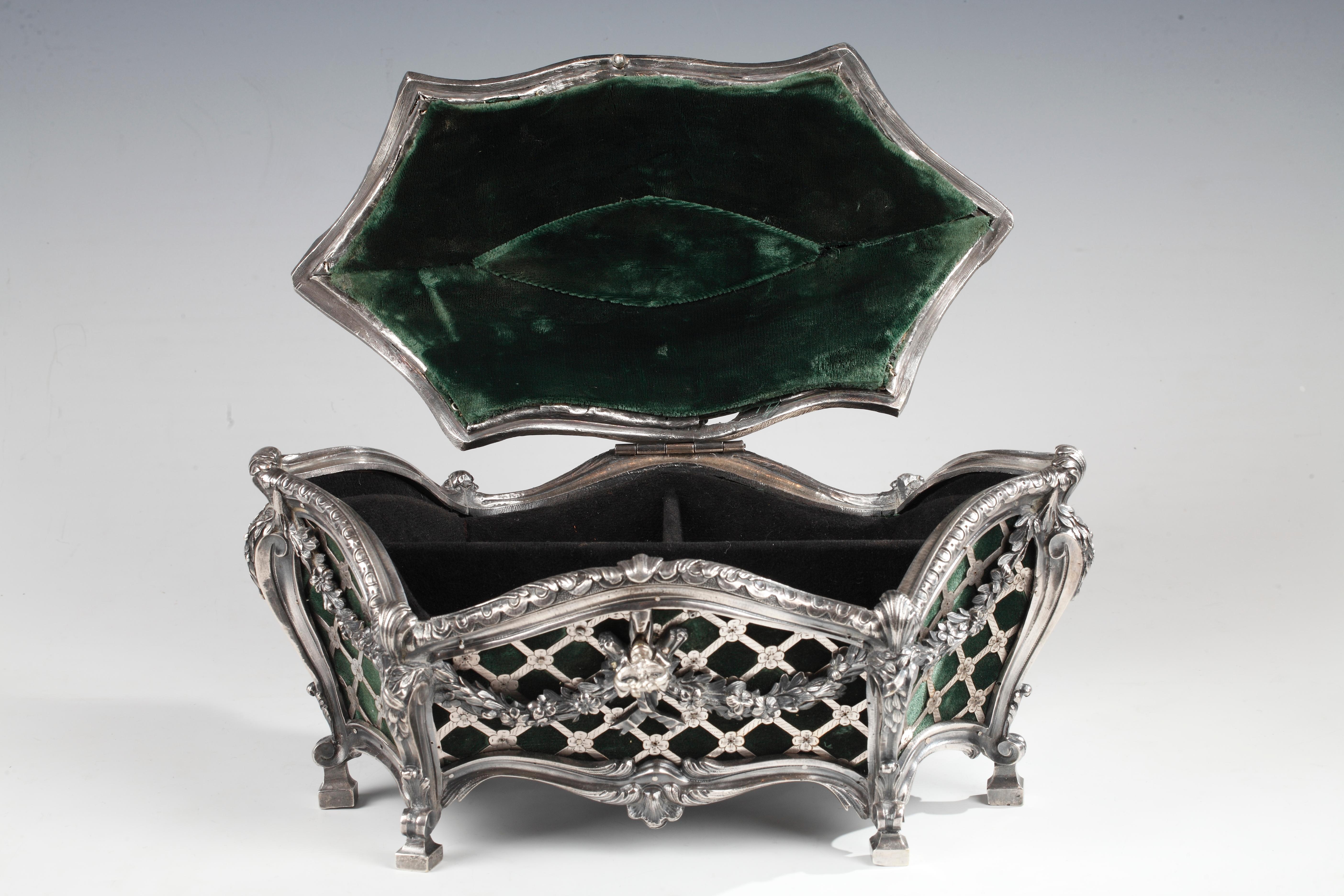 An elegant and asymmetric rocaille style silvered bronze coffer attributed to Tahan, and decorated with openwork flowery trellis upon a green silk velvet. Fine ornamentation of flower garlands and scrolls.
The coffer has two black coated