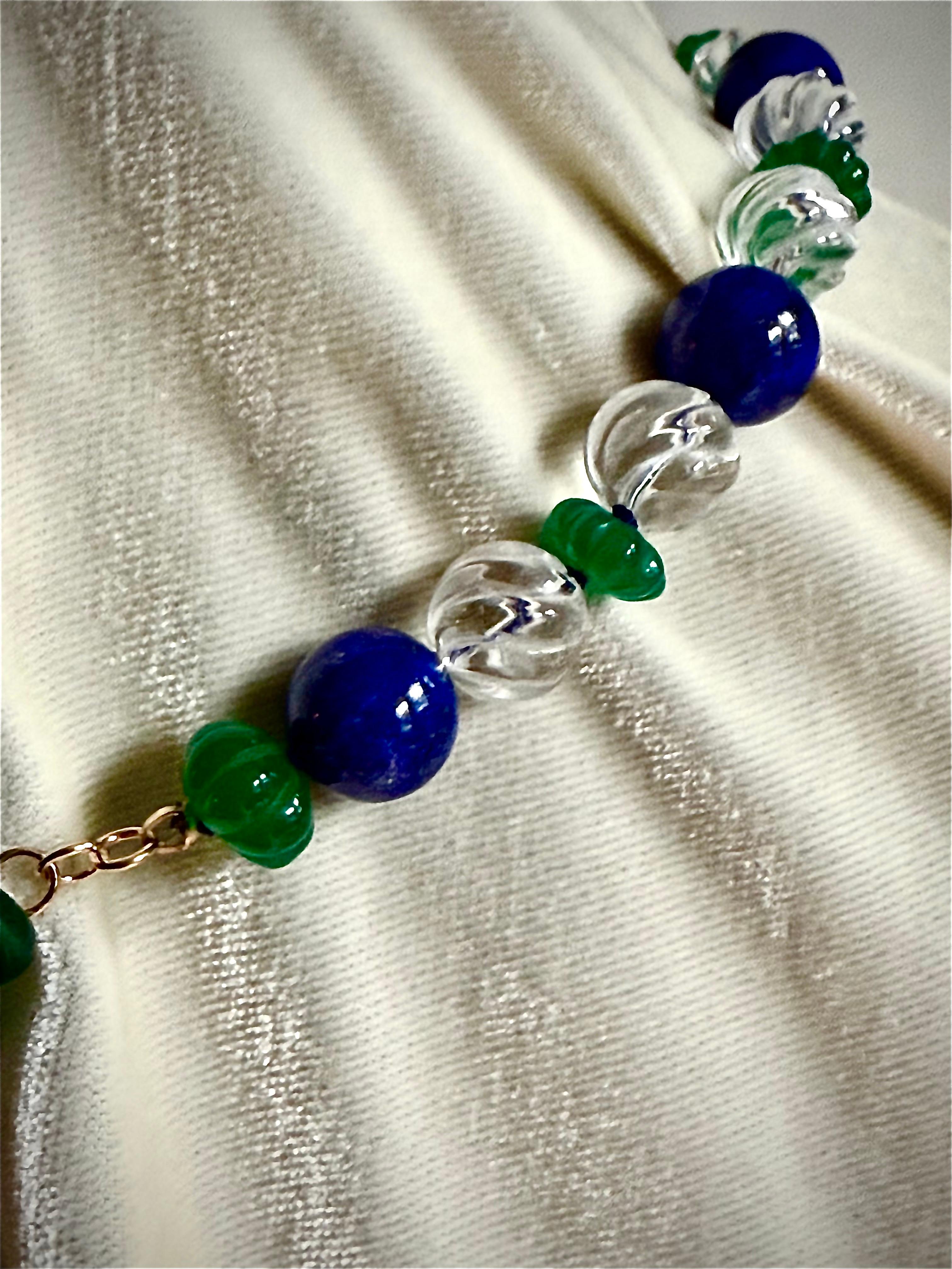 Diese einsträngige Halskette ist sehr opulent und elegant in ihrer Kombination aus geschliffenen Bergkristallkugeln mit Wirbelmuster, tiefblauen polierten runden Lapislazuli-Perlen und geschnitzten melonenförmigen grünen Onyx-Rondellen. 

Die