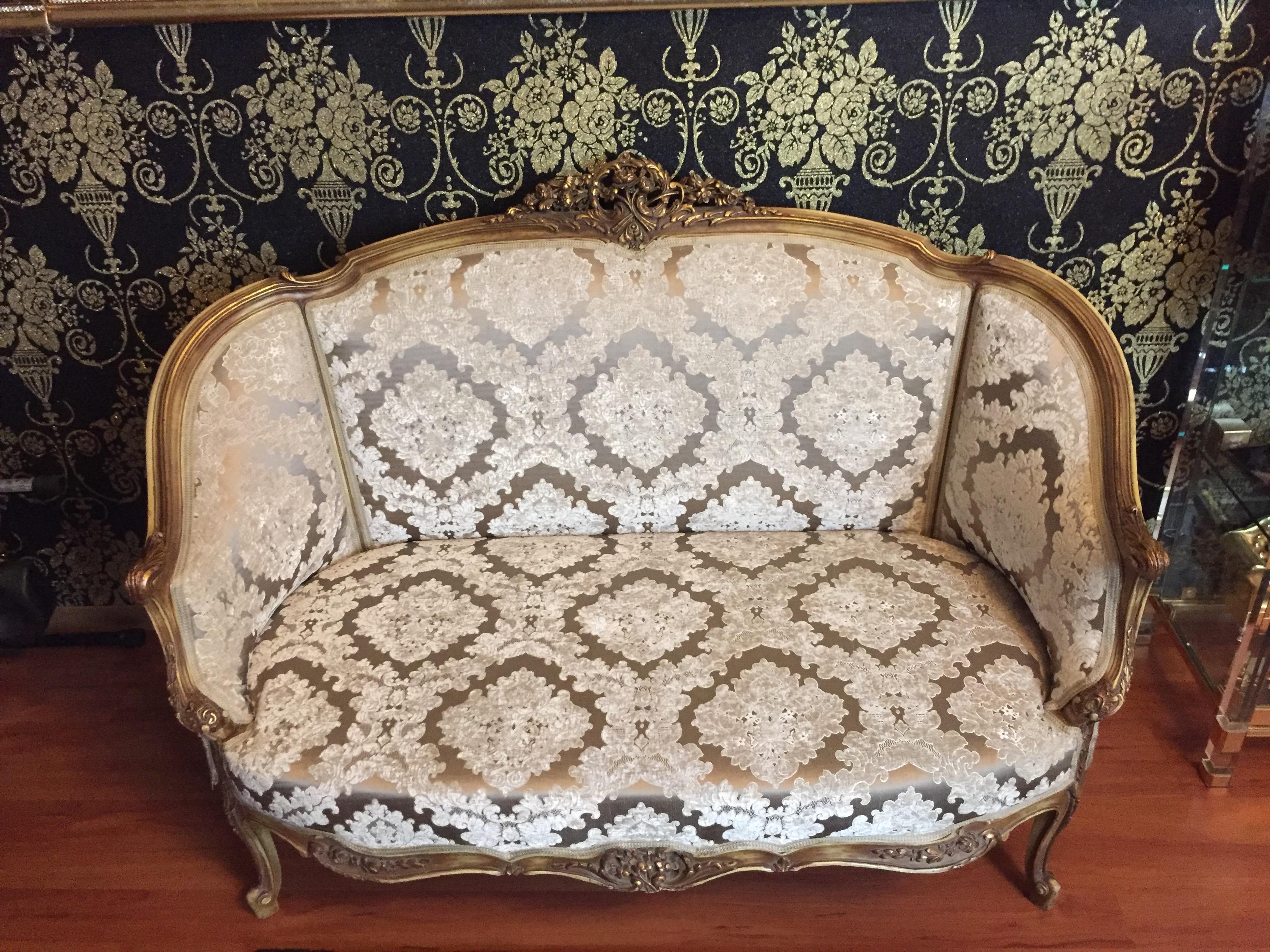 Solid beechwood, carved and gilded. Rising backrest framing with openwork rocaille crowning. Appropriately curved frame with richly carved foliage. Slightly curved frame on curved legs. Seat and backrest are finished with a historical, classic