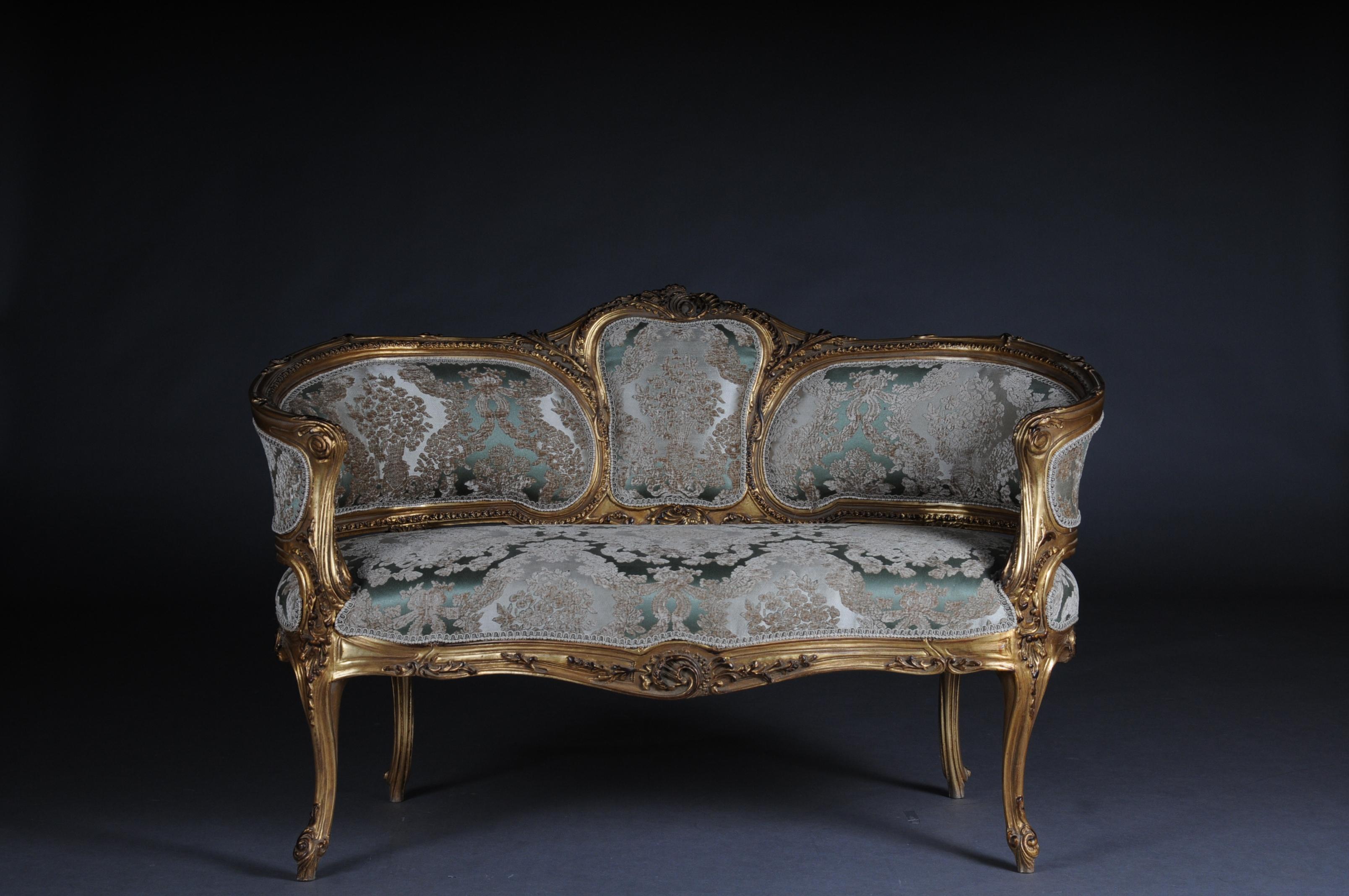 Solid beech wood, carved and gilded. Rising backrest framing with openwork rocaille crowning. Appropriately curved frame with richly carved foliage. Slightly curved frame on straight legs. Seat and backrest are finished with a historical, classic
