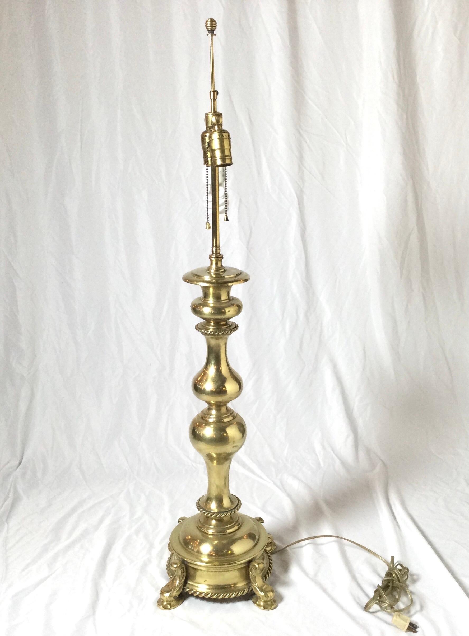 A tall and solid cast brass lamp, attributed to chapman. The shapely center colon on round footed plinth base with rope trim detail. The shade is for photographic purposes and not included. The height as pictured is 40 Inches tall but it is