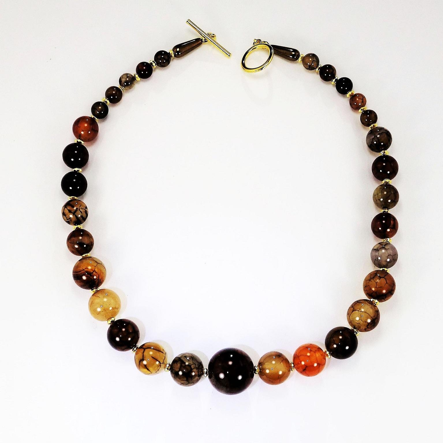 Necklace of four sizes of glowing Spider Web Jasper beads. These highly polished, gorgeous beads are in multi shades of brown, tan, rust, with black veining and each individual bead is interesting. The beads are accented with gold tone fluted