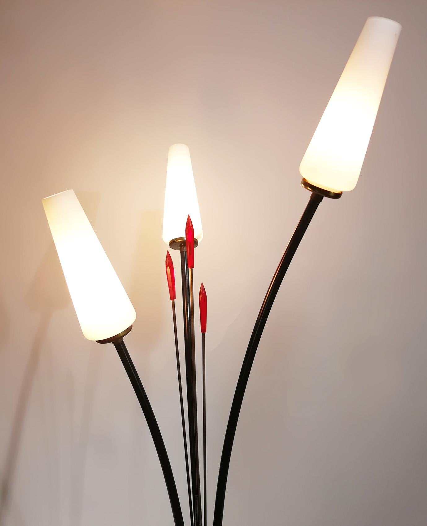 Un superbe lampadaire de style Stilnovo avec trois abat-jour en verre et une lance en Lucite rouge, fabriqué dans les années 1950 en Italie. Cette élégante lampe en forme de fleur est fabriquée en laiton.
L'aspect suave et élégant est