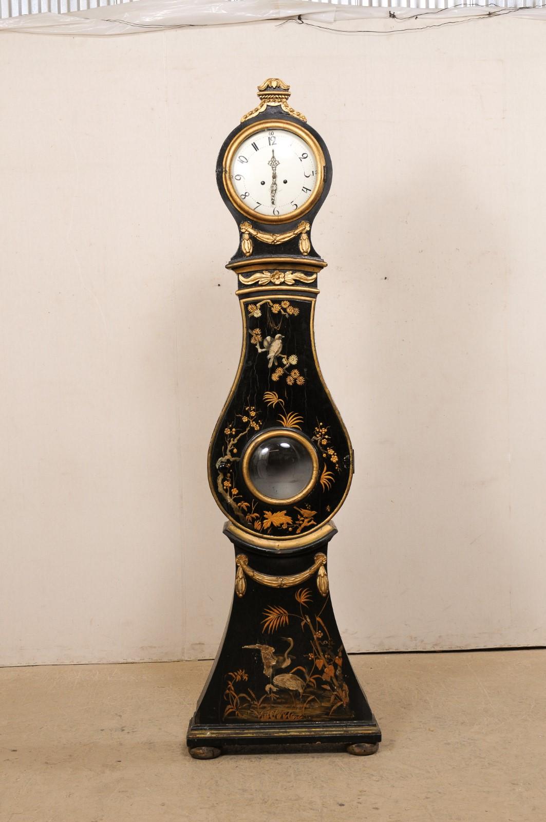 An elegant Swedish grandfather clock adorn with a distinctive chinoiserie nature inspired design from the early 19th century. This antique floor clock from Sweden is loaded with decorative chinoiserie throughout, in a playful nature motif of cranes,