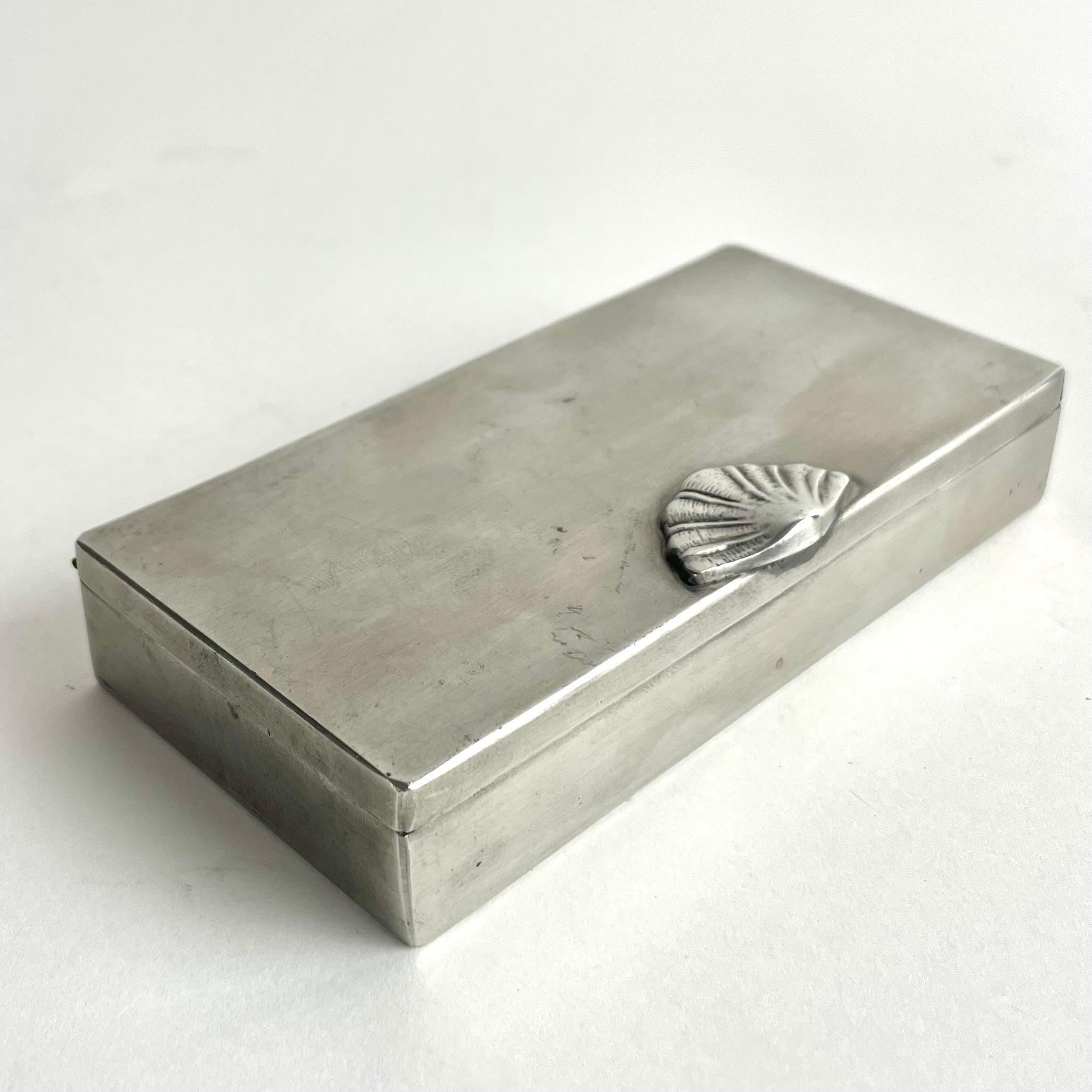 
Elegant Swedish Grace pewter box with shell motif, GAB 1927

Refined pewter box by GAB (Guldsmedsaktiebolaget), dated 1927 (hallmarked with date letter “A8”). A beautiful example of the Swedish Grace style, featuring a minimalist rectangular form