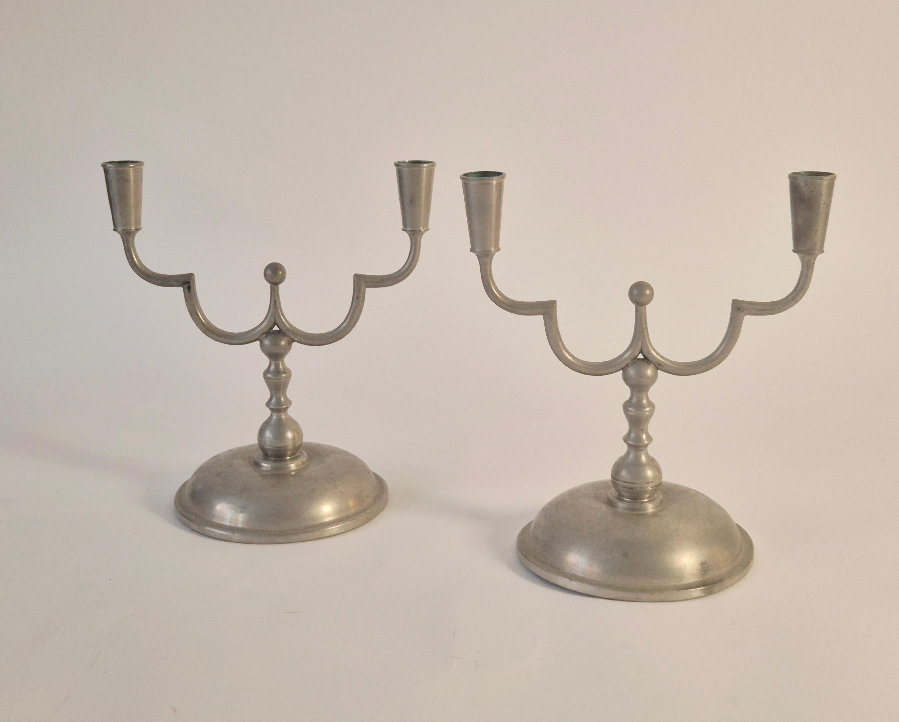 Una coppia di eleganti candelabri in peltro Swedish Grace, prodotti da Herman Bergman nel 1929.

In buone condizioni, una base con un'ammaccatura e un fondo con un graffio. Una bella patina nel complesso.