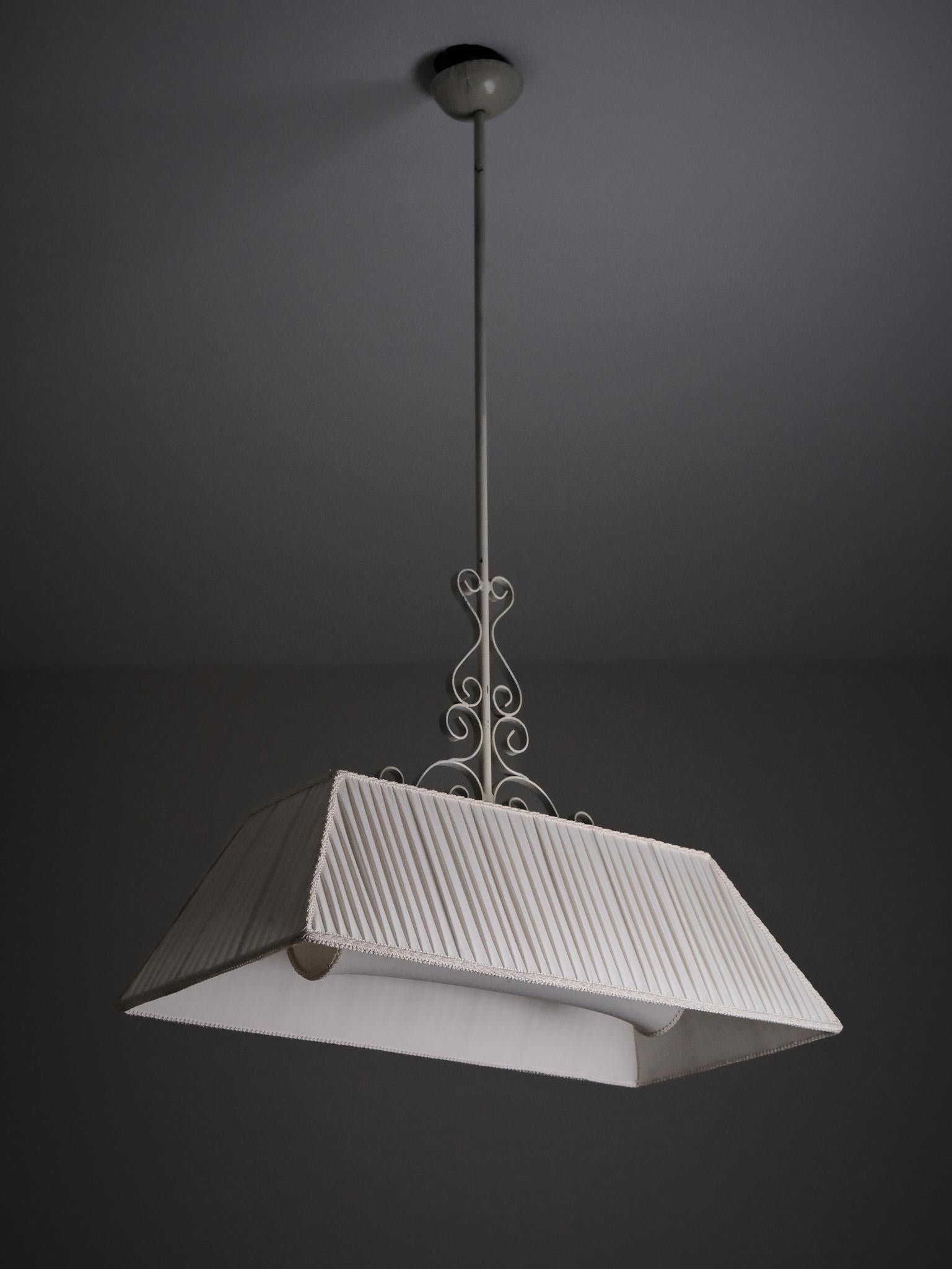 Una lampada da soffitto moderna svedese degli anni '40, disegnata da un produttore sconosciuto.

Realizzata in ferro verniciato e tessuto, la lampada presenta un dettaglio decorativo a volute e un paralume morbidamente plissettato. La forma