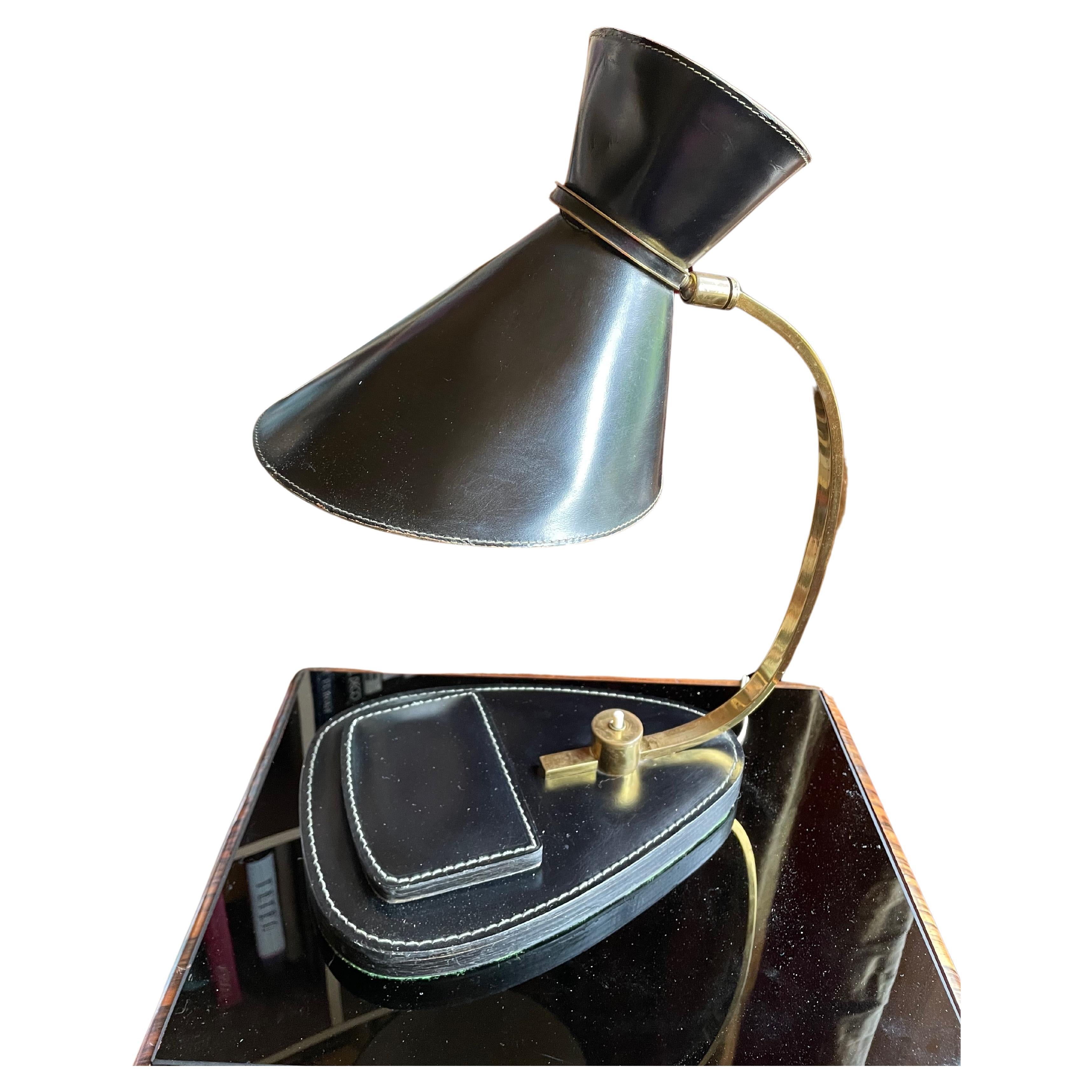 Jacques Adnet Elegant table lamp, France 1950s.
Hand-stiched leather.
Brass with slight signs of use due to age.
with swivel shade.
Hinged box
Good condition.
The shade is slightly dented in a few places.
No missing parts in the leather, no torn