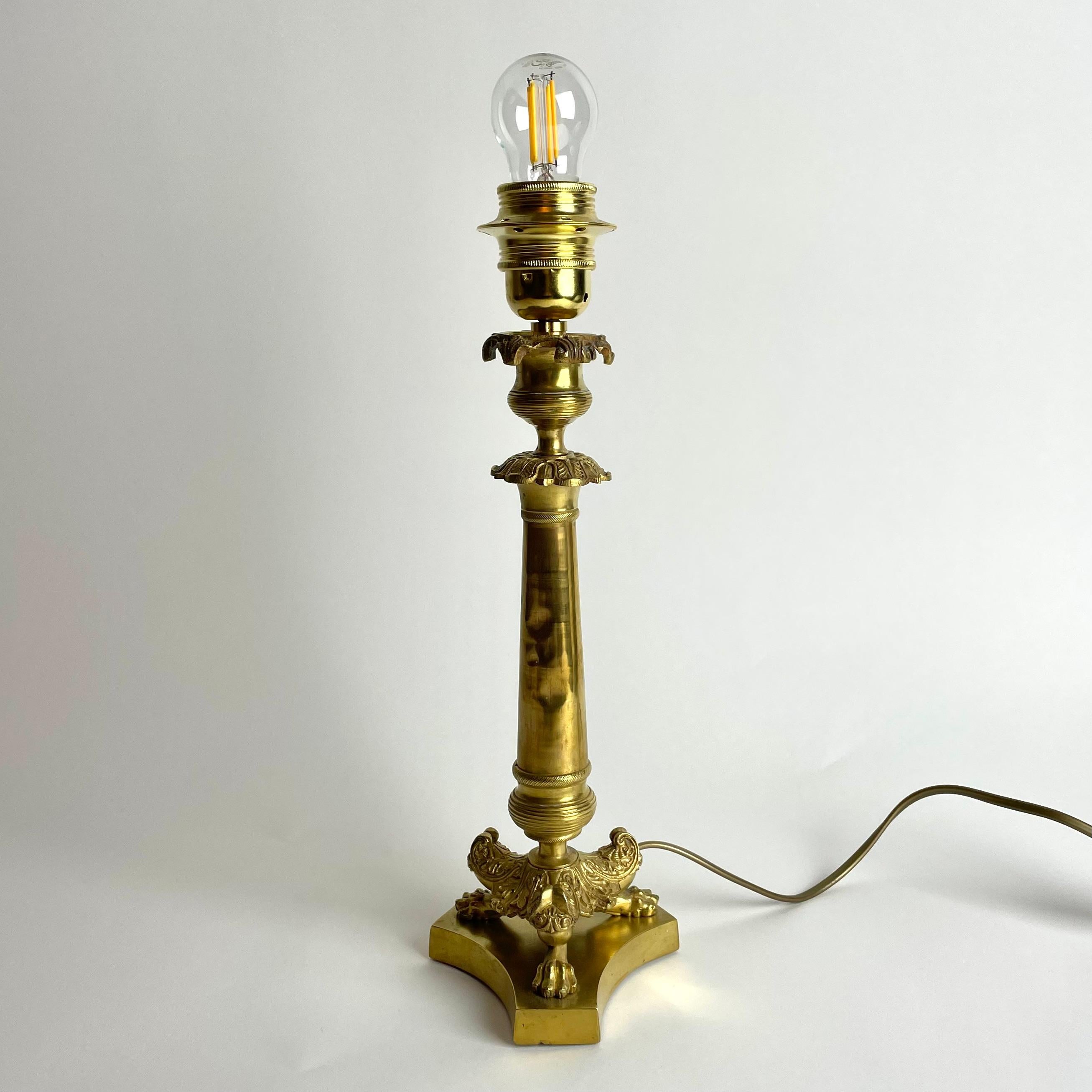 Elegant Table Lamp in bronze. Originally an Empire candlestick from France made during the 1820s. Richly decorated with period Empire decorations.

Newly rewired electricity.

Wear consistent with age and use.