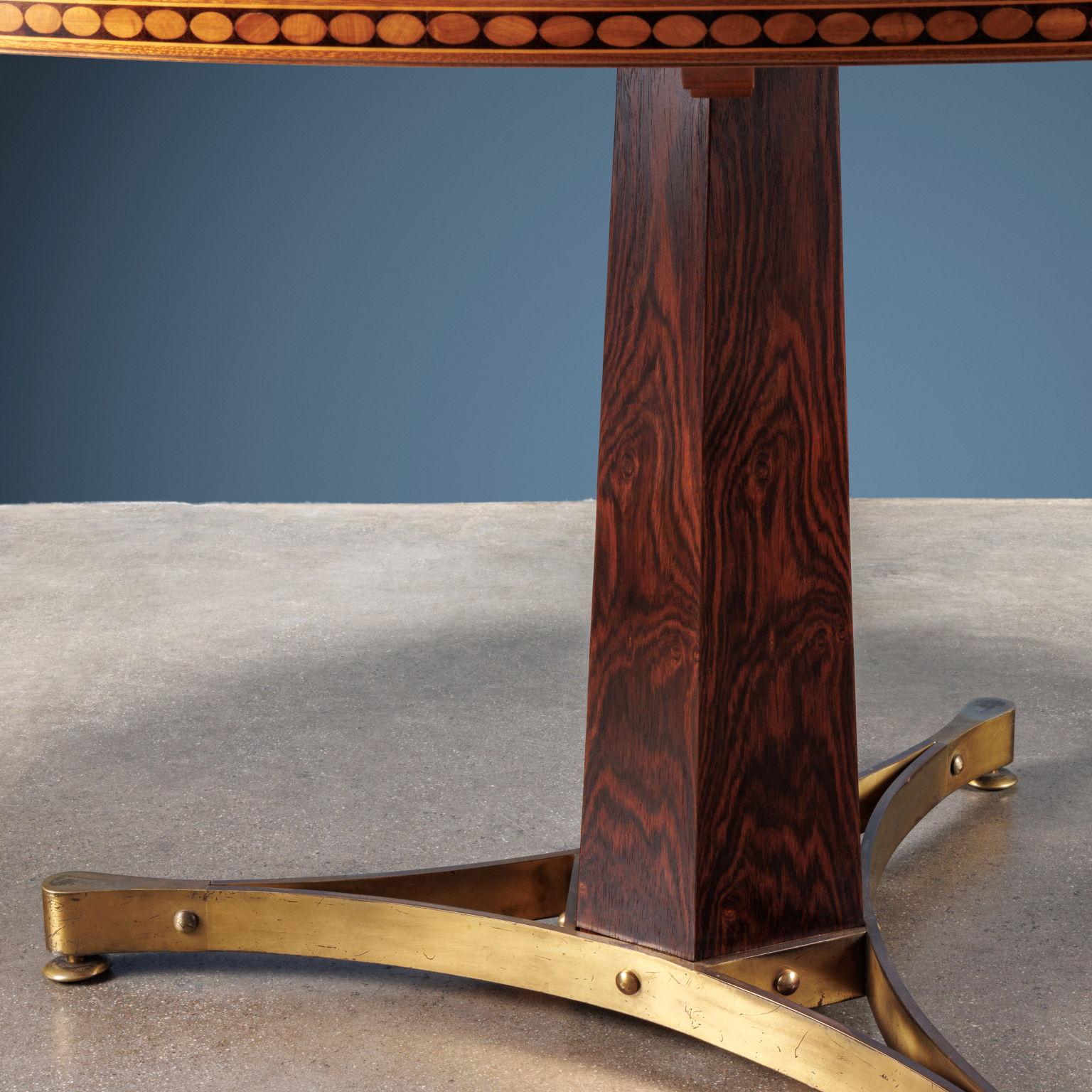 Elegant table with brass base with three support points, central hexagonal shaped stem in solid wood veneered in Rosewood, top in Mahogany veneer, precious decorative motif inlaid on the perimeter of the top with 'thread' in Maple and motifs in