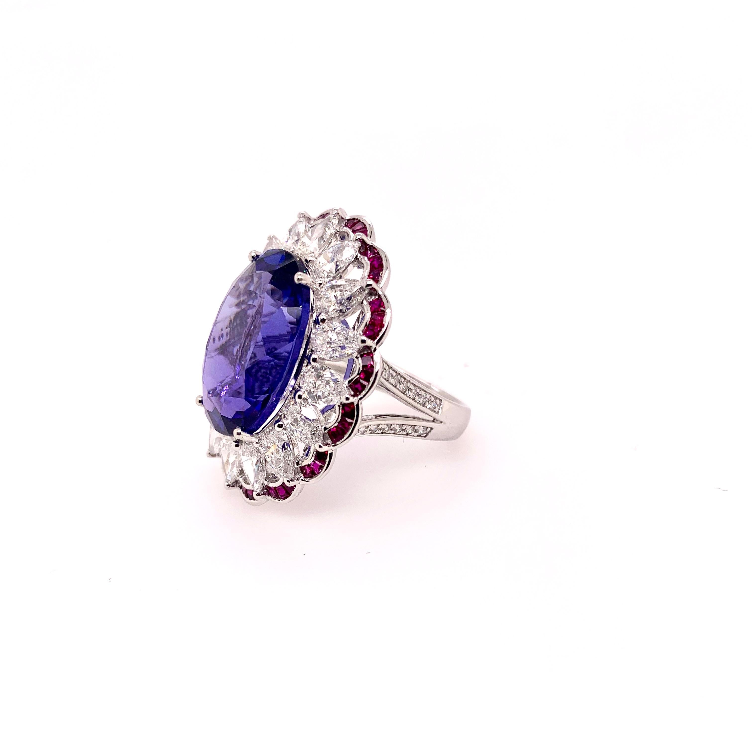 This elegant tanzanite ring was meticulously designed and crafted using the wonderful color combination of rubies and diamonds in a platinum setting.  The 15.5 carat oval tanzanite glistens with the red and purple hues.  It is supported by the 1