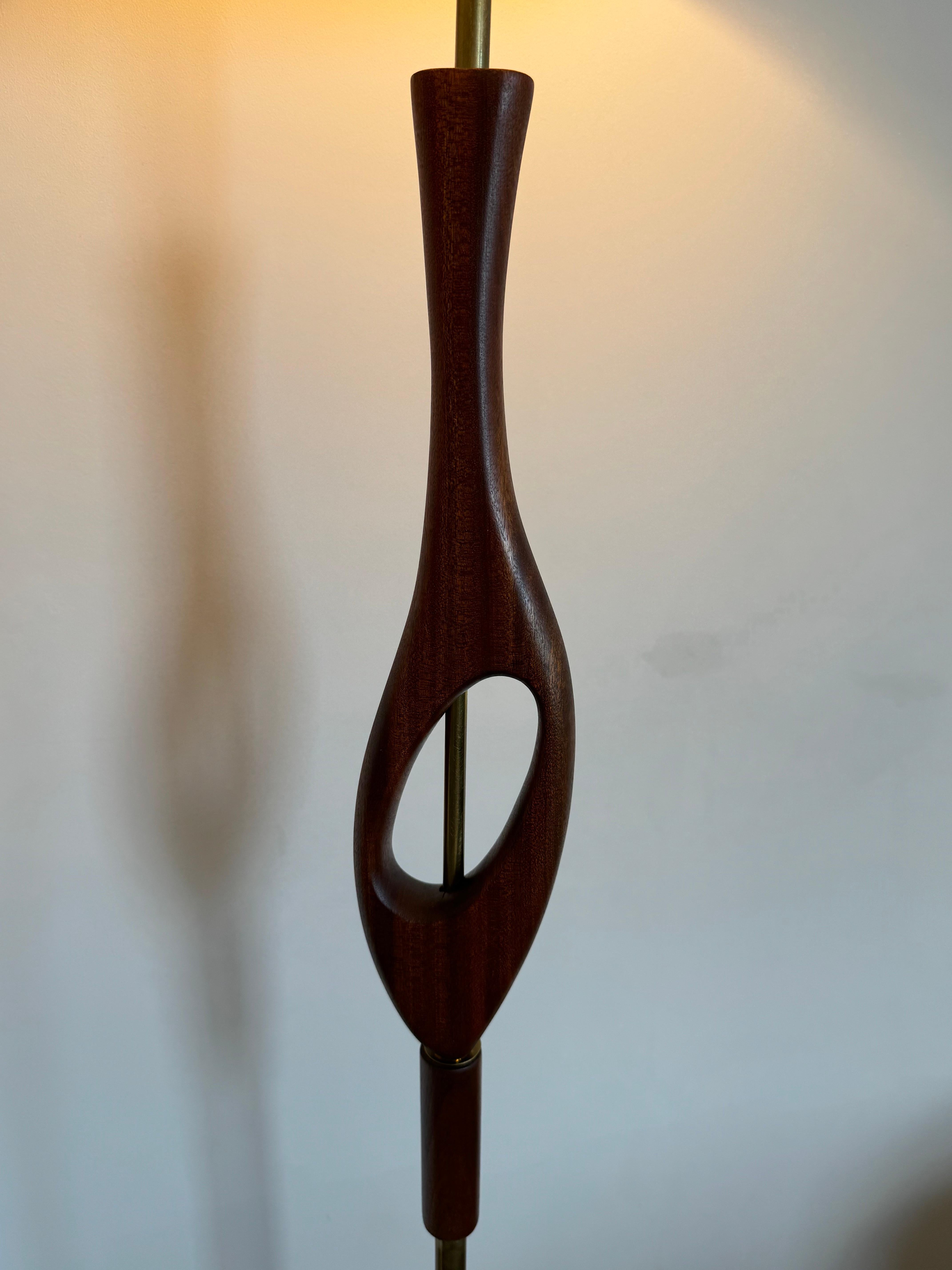 Elegant floor lamp by with teak and parts of metal. The lamp has a new circular lampshade (format H30, D40cm ). 

The lamp is overall in a good condition but it is a vintage item and it may have some wear such as scratches and other signs of