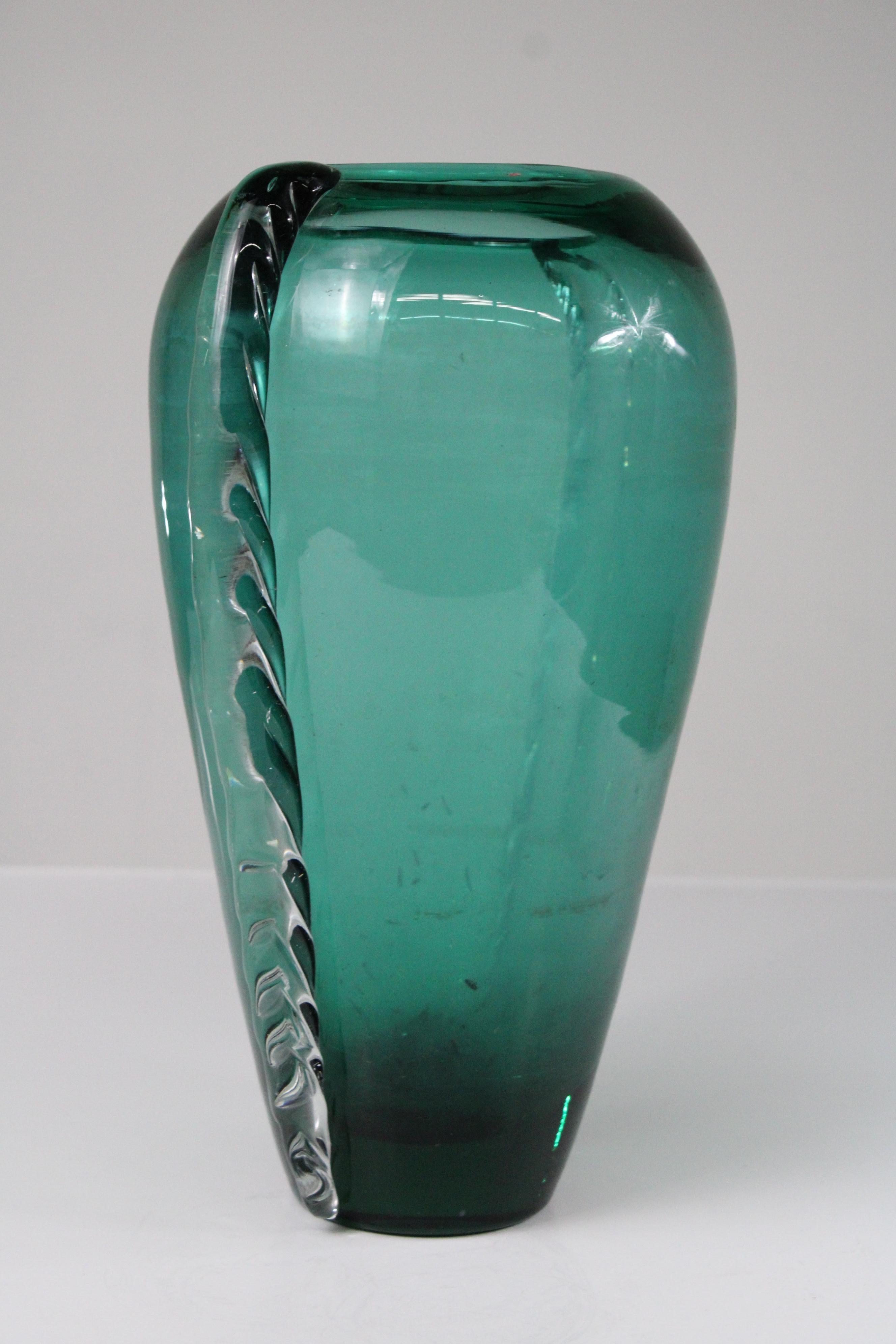 Diese atemberaubende Vase aus Murano-Glas in einem satten Teal-Farbton verkörpert die zeitlose Eleganz der italienischen Glaskunst. Die von erfahrenen Handwerkern mundgeblasene Vase zeichnet sich durch anmutige Kurven und eine glatte, leuchtende