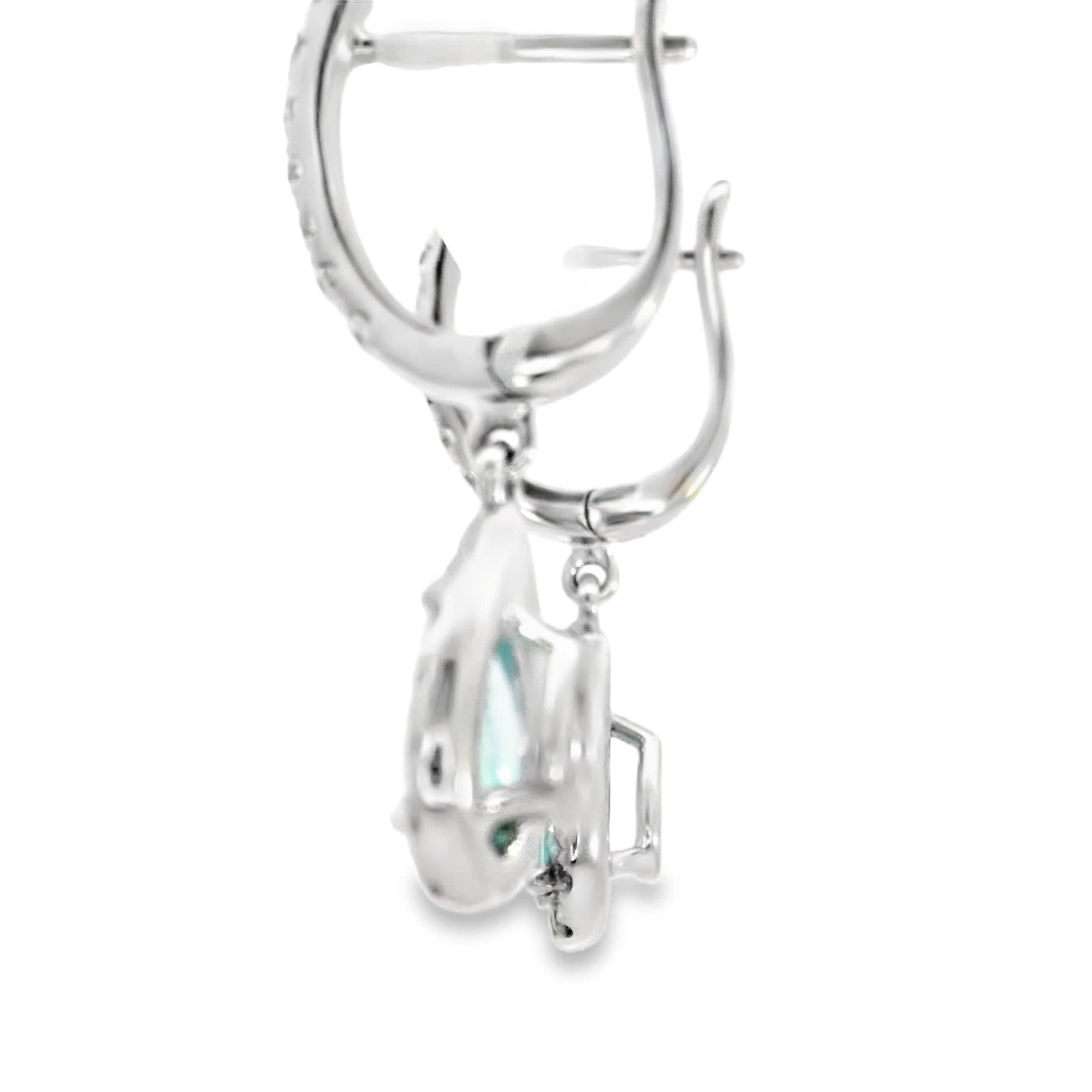 Questi splendidi orecchini a goccia presentano un'affascinante gemma color acqua circondata da un'aureola di diamanti scintillanti. Perfetti per aggiungere un tocco di eleganza a qualsiasi vestito, sono progettati per catturare la luce in modo