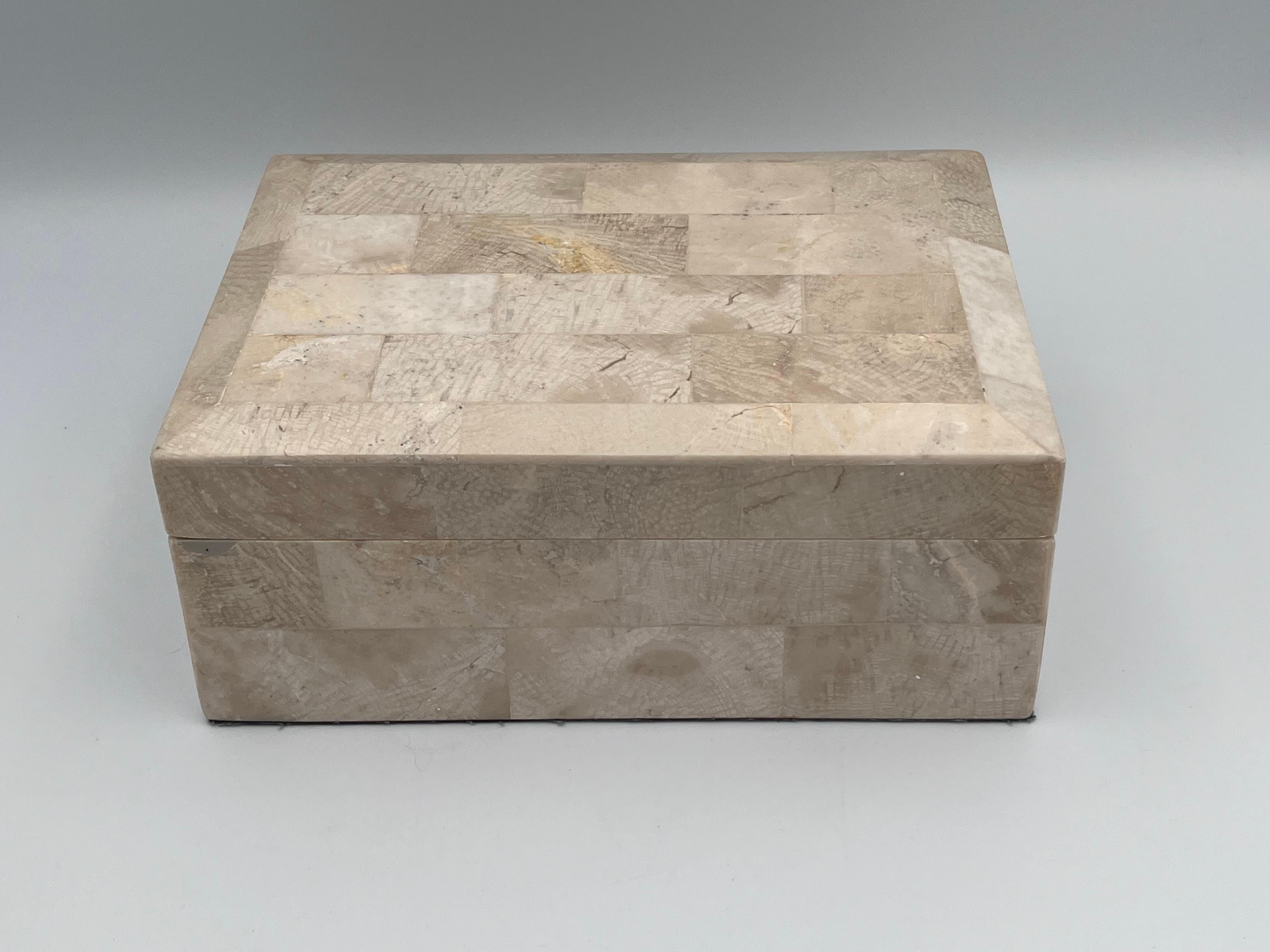 Elegant Tessellated Stone Fossilized Wood Decorative Catchall Beveled Box, Possibly by Maitland Smith, 20th Century

This elegant tessellated stone decorative box features a striking inlay of fossilized wood arranged in a precise brick-grid pattern,