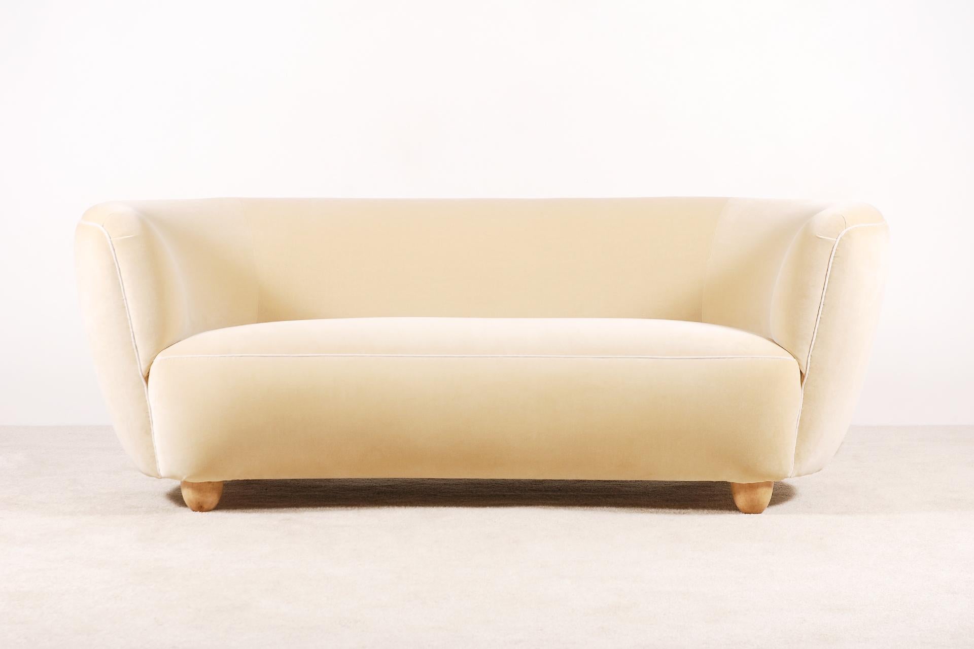 Rare and elegant three-seat curved sofa manufactured in Denmark, in the 1940s.
Very soft and comfortable seat. Light oak feet.
Perfect condition.
This sofa has been fully restored and newly upholstered with a high quality cream/beige velvet