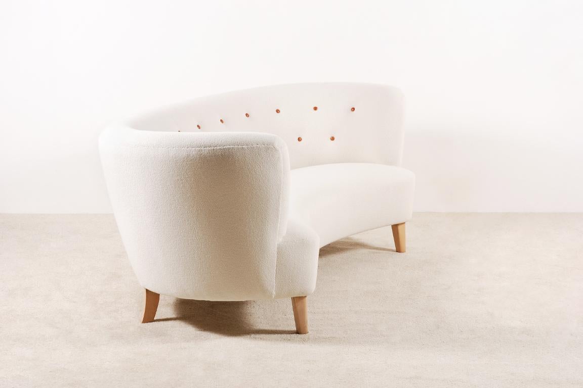 Sehr elegantes, geschwungenes Dreisitzer-Sofa aus Dänemark, hergestellt in den 1940er Jahren. Sehr weicher und bequemer Sitz. Füße aus Buche. Knöpfe aus Leder. 

Perfekter Zustand, neu gepolstert mit einem hochwertigen 100% Wollstoff der