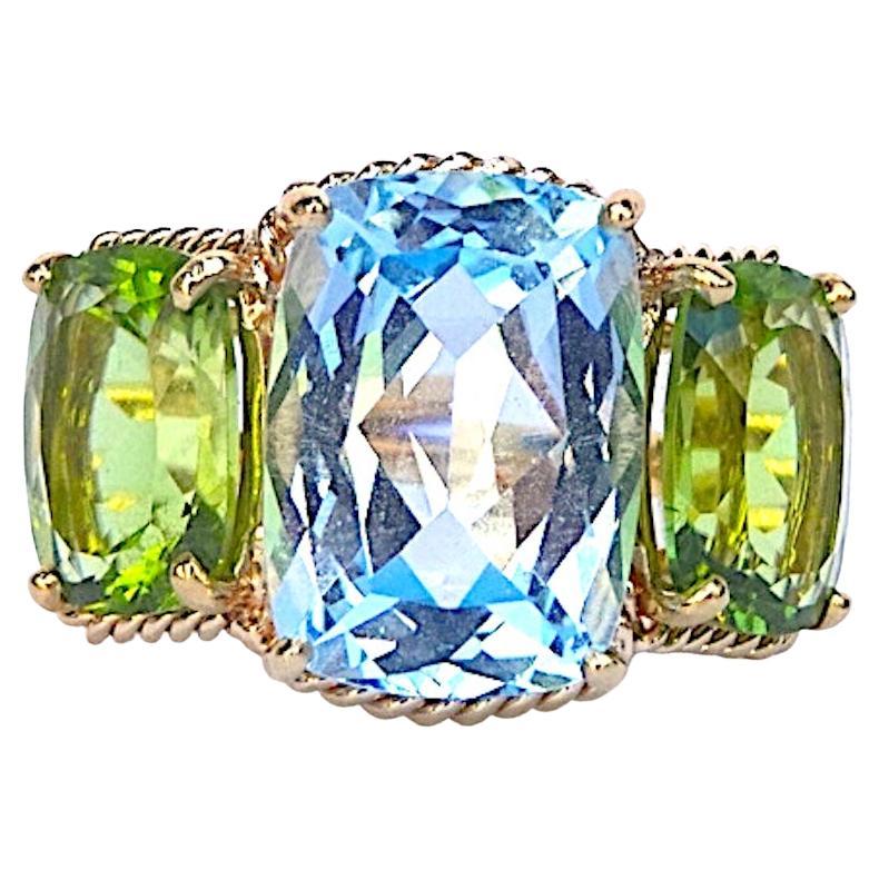 Elegante Anillo de Tres Piedras de Topacio Azul y Peridoto con Bordes Torcidos de Cuerda de Oro