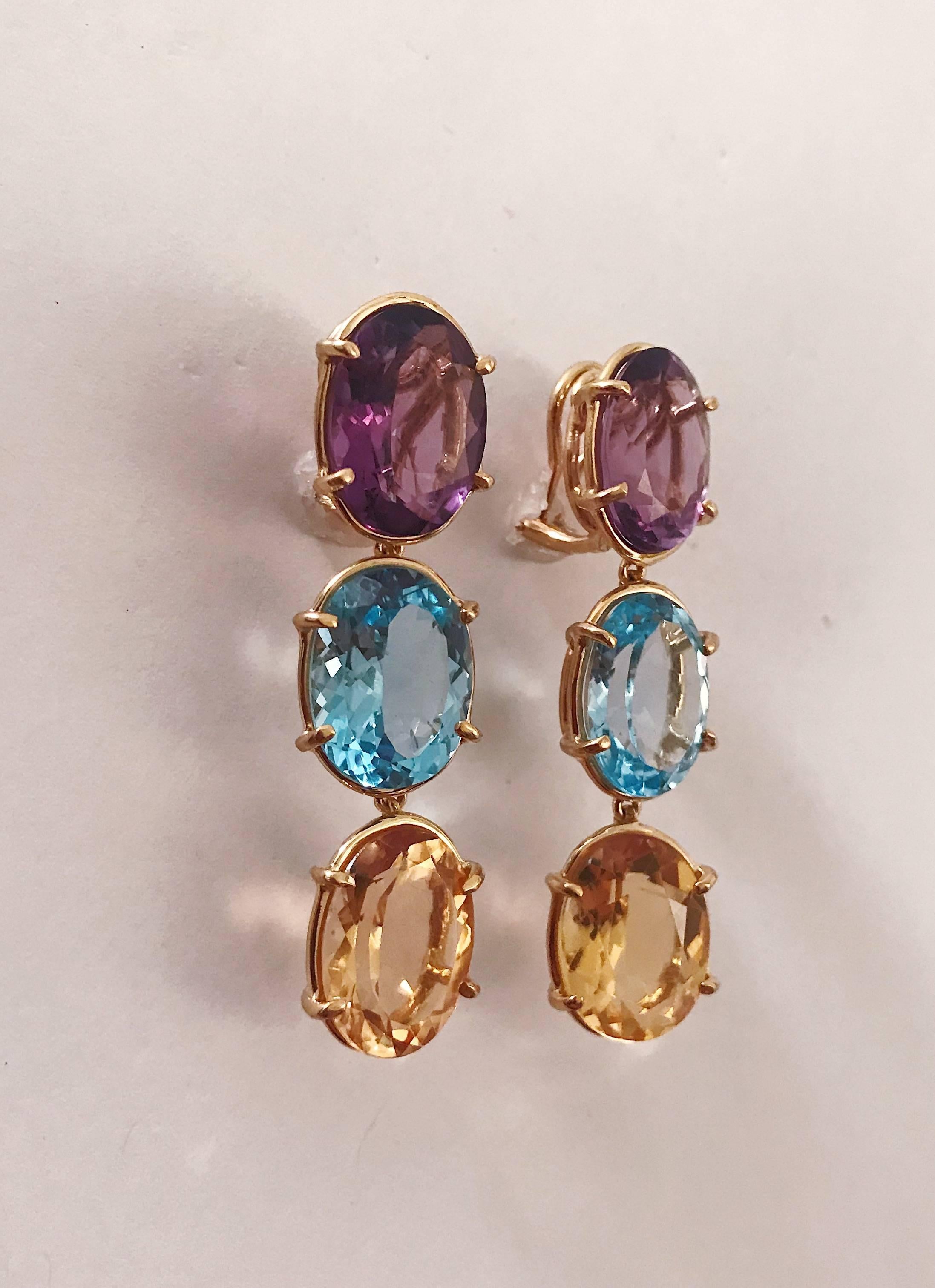 18kt Yellow Gold Elegant Three Stone Drop Earrings with faceted oval Amethyst and Blue Topaz and Citrine.

The Earrings measure 2 1/4 in length. The earrings can be made for Clip Earring or Pierced Earrings. They can also be custom made with any