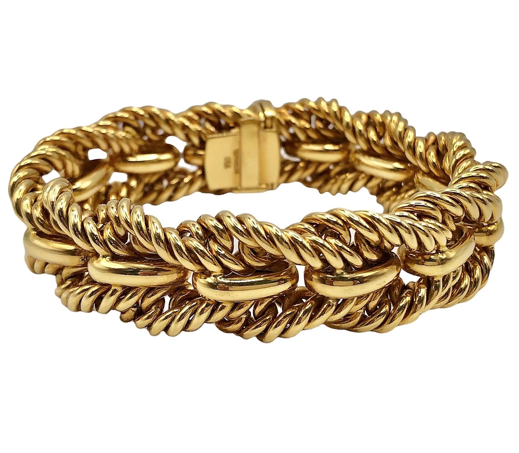 This elegant 18k yellow gold Tiffany & Co. bracelet is designed with two rope edges bracketing a center line of repeating high polish bombe motifs.  Measures 7 3/8 inches in length by 5/8 inches in width. The inline plunger clasp is made more secure