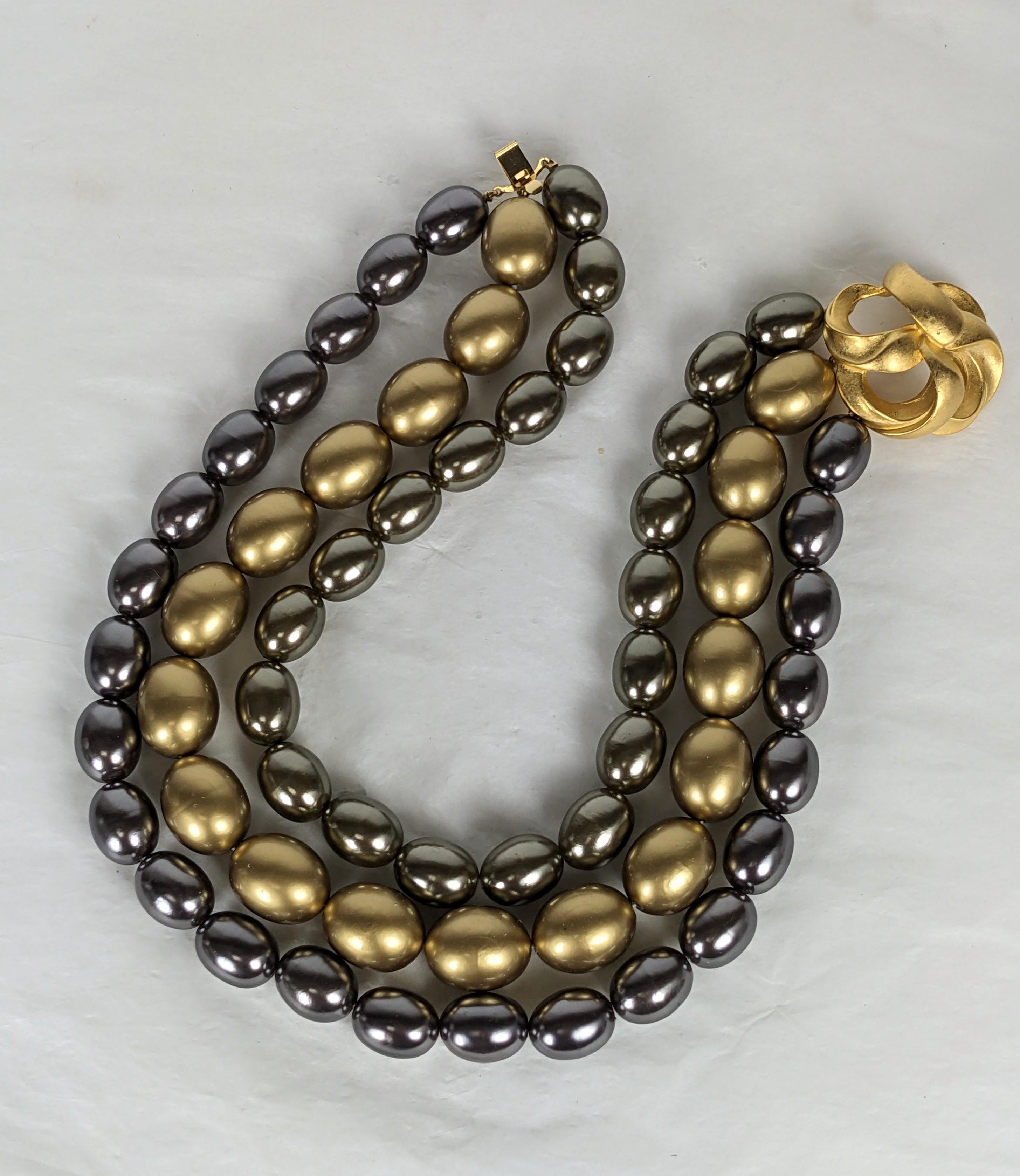 Elegantes, tonales Kunstperlenhalsband aus den 1990er Jahren. 3 Stränge mit ovalen Kunstperlen in verschiedenen Tönen und Größen mit mattgoldenem Verschluss. Die Perlen können in verschiedenen Konfigurationen getragen werden. 16
