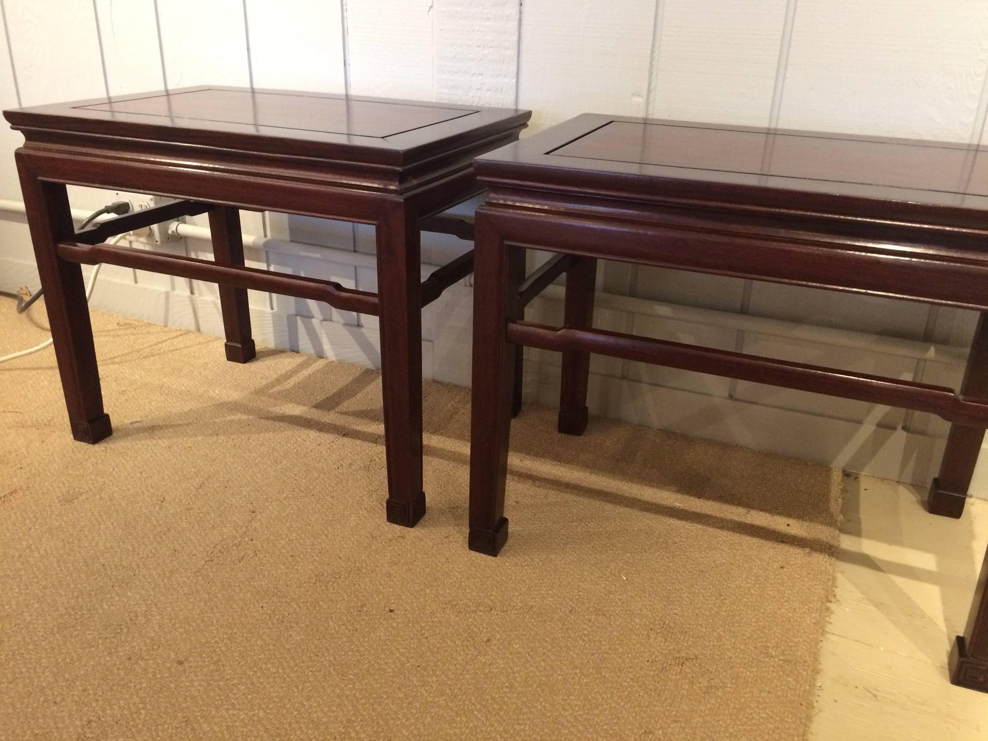 Two handsome rich mahogany end tables having a carved black band around the top periphery and elegant legs with Greek key carved feet.  SW