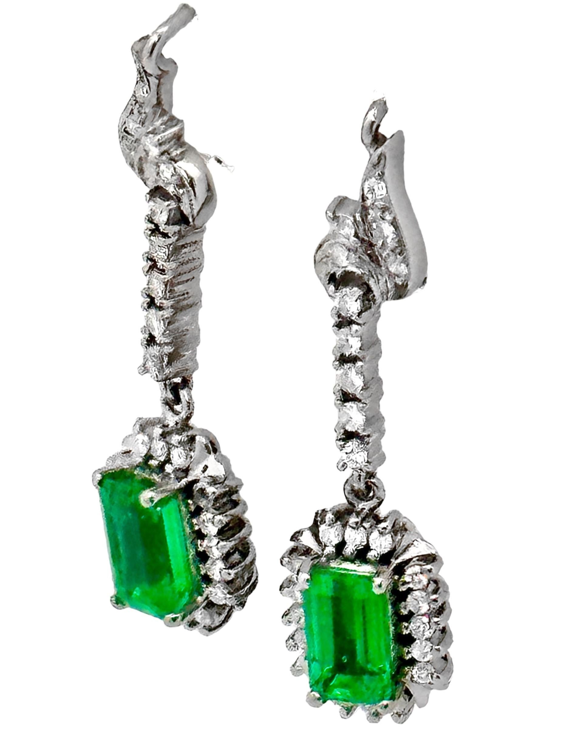 This classic pair of earrings, crafted in 18k white gold, is set with two vibrant and vivid natural emerald cut emeralds which have an approximate total weight of 2.00ct. The entirety of the pair is set top to bottom with small brilliant cut