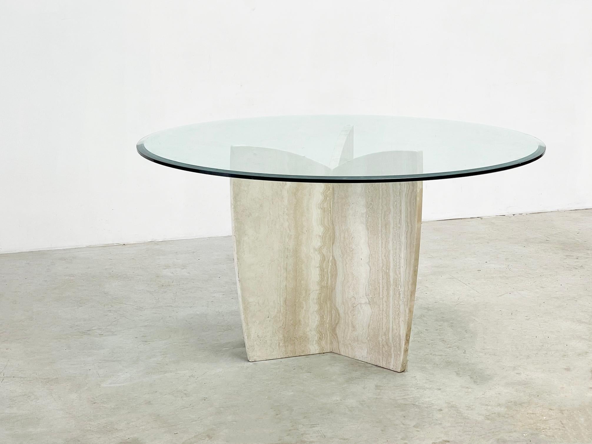  

Dieser Esstisch aus Travertin mit einer Glasplatte ist wahrscheinlich von  in den 1980er Jahren aus Italien. Sein elegantes Design und die italienische Handwerkskunst machen ihn zu einem zeitlosen Mittelpunkt für jeden Essbereich. Es passen
