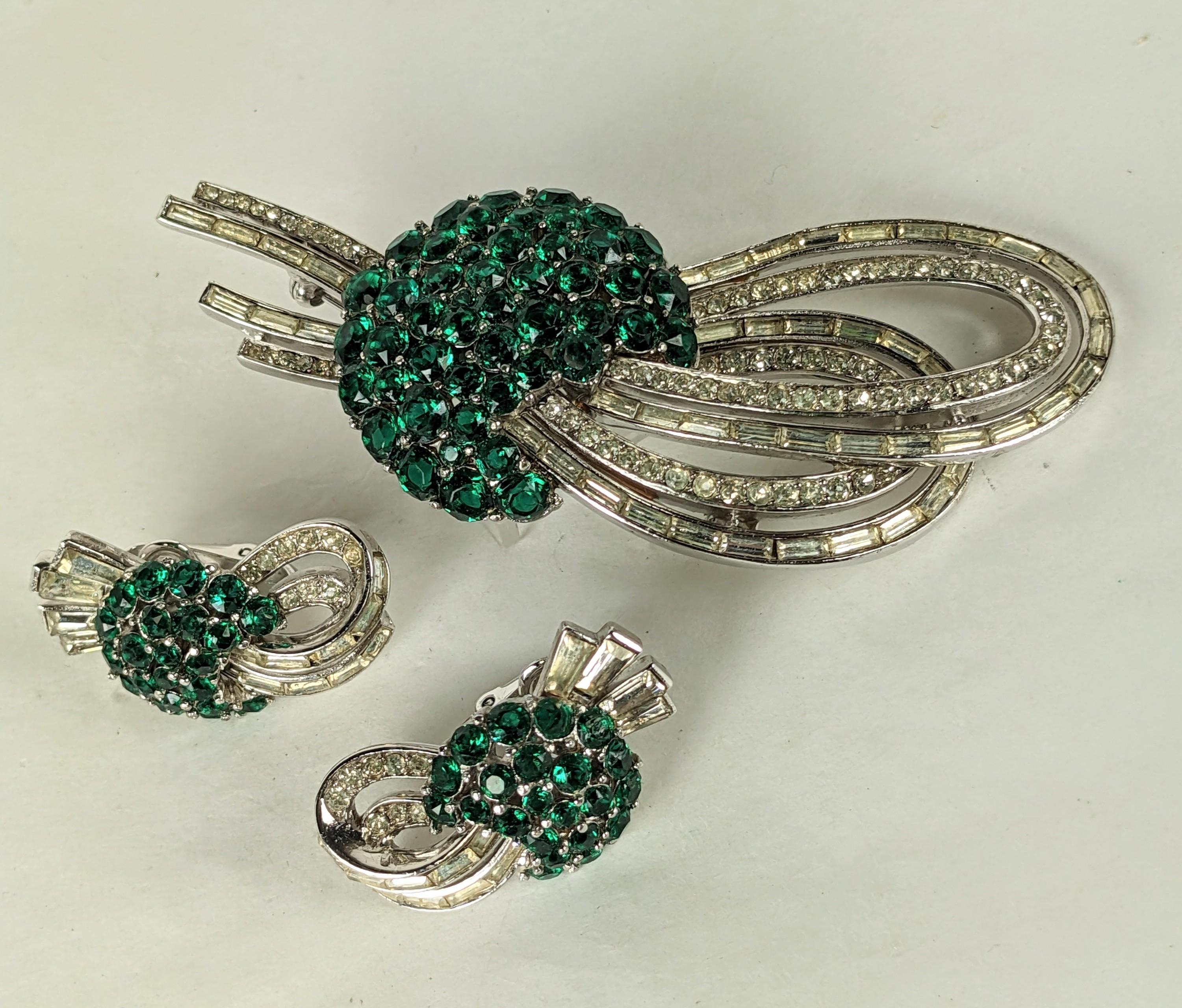 Elegant Trifari Emerald Comet Suite from the 1950's by Alfred Phillipe. Brooch has a central motif of pave faux emeralds with loops of pave and baguette set swirls. Matching clip earrings.
1950's USA. 3.25