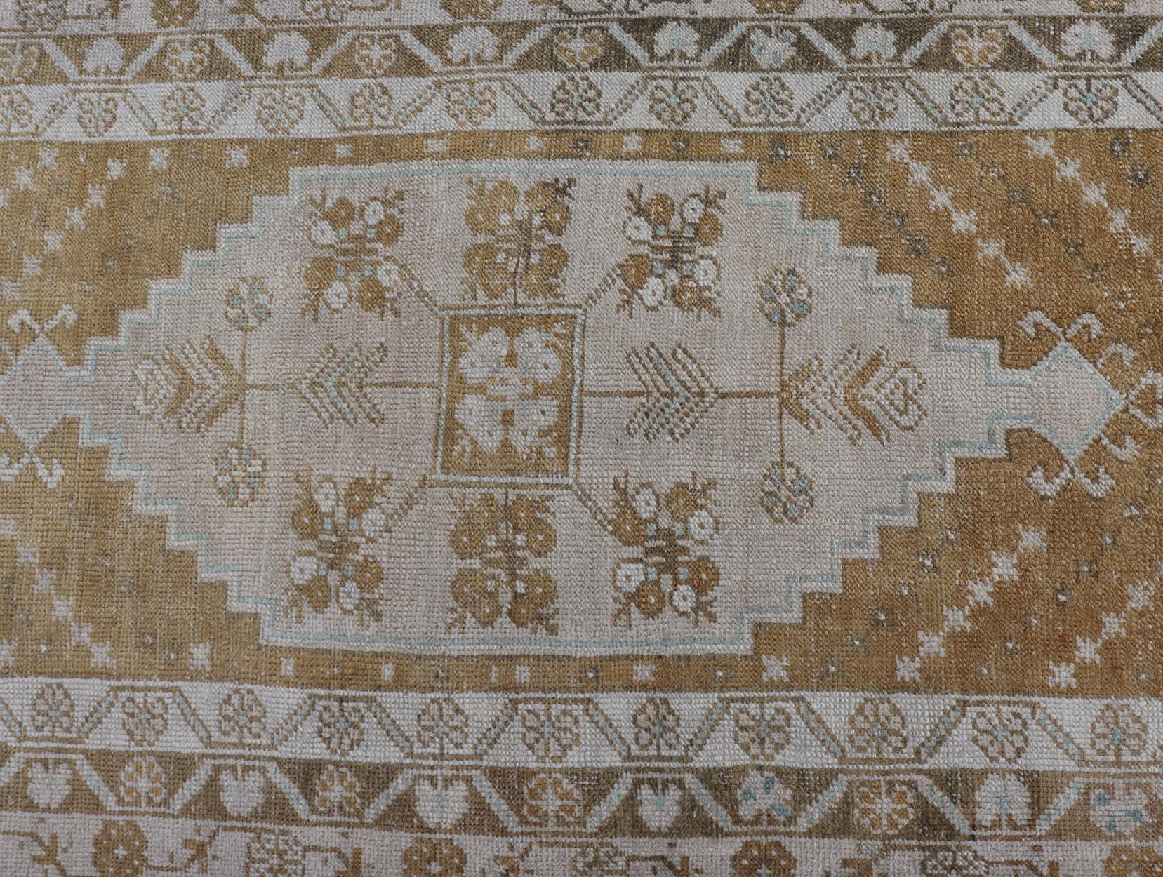 Measures: 2'9 x 10'1 This image features an elegant Turkish Oushak runner, characterized by its exquisite design and sophisticated color palette. The runner showcases a series of geometric medallions running along its length, each intricately