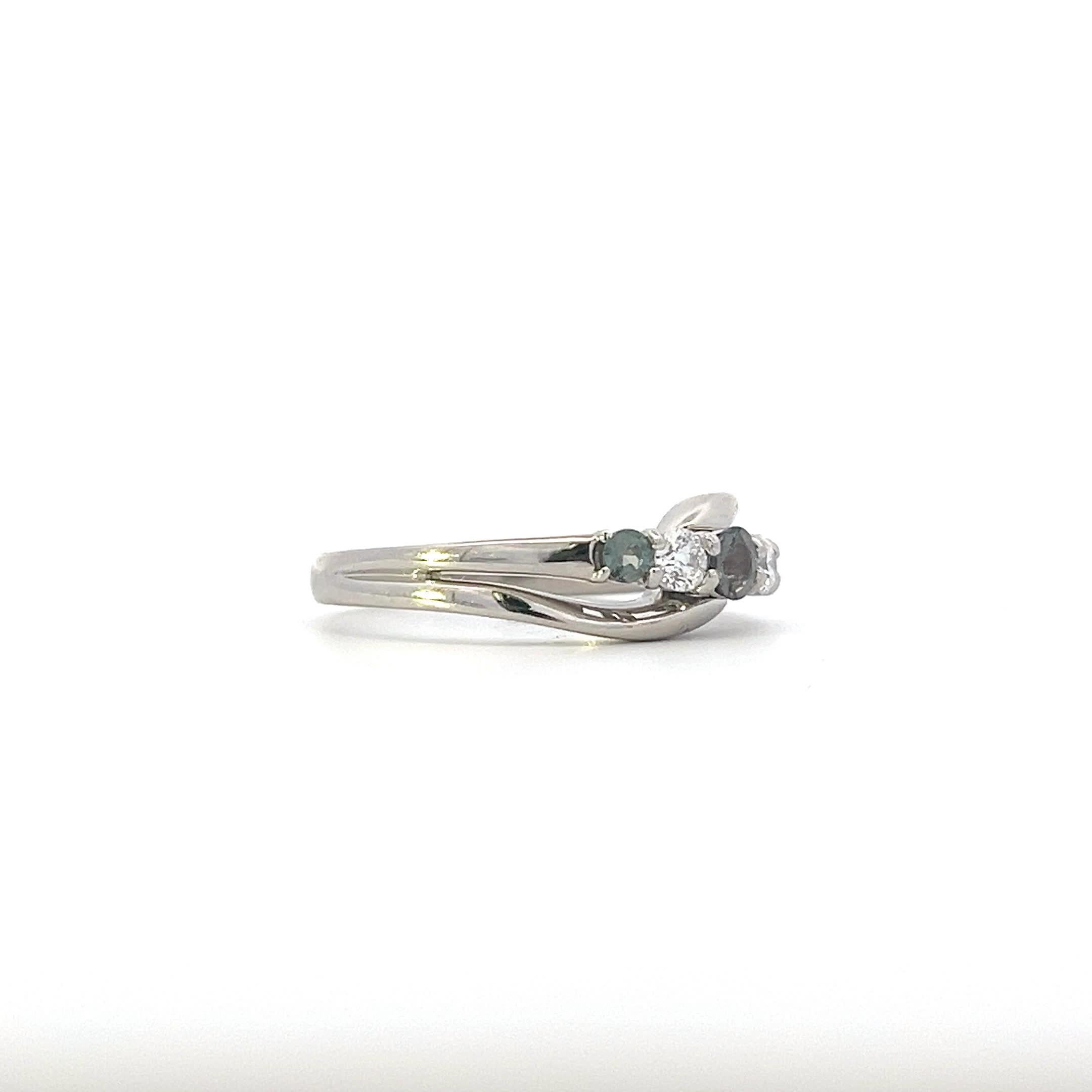Entdecken Sie die Schönheit dieses eleganten Rings mit gedrehtem Band, der eine atemberaubende Kombination aus funkelnden Diamanten und tiefgrünen Edelsteinen aufweist. Ihr einzigartiges Design verleiht jedem Outfit einen Hauch von Raffinesse und
