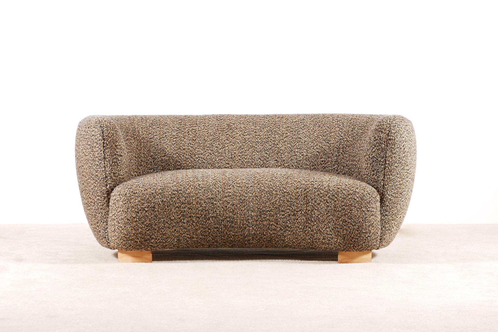 Very elegant two-seat curved sofa manufactured in Denmark during the 1940s.
Lovely shape and curves. Very comfortable seat.
Oakwood natural color waxed feet.

This sofa has been fully restored and newly upholstered in the traditional way by the