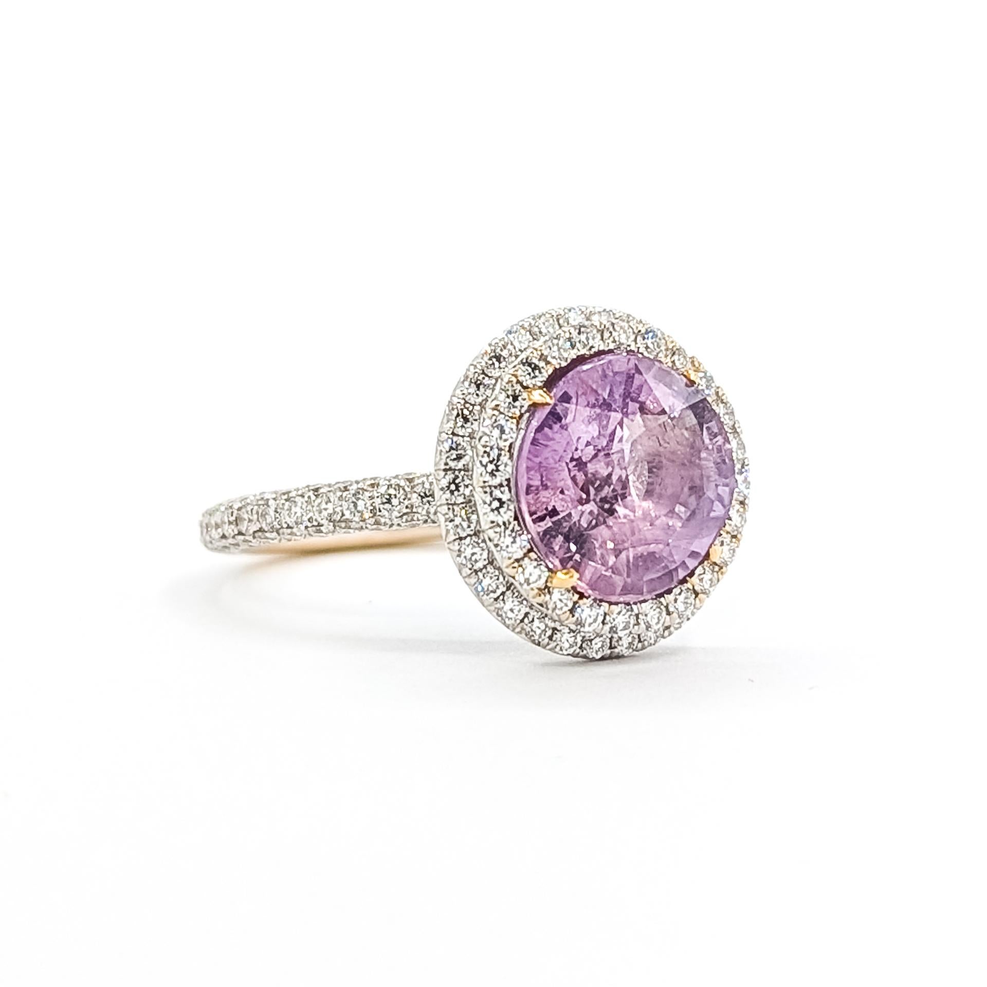 Questo squisito anello è realizzato in oro bianco 18 carati e mette in mostra un vivido zaffiro rosa non riscaldato del peso di circa 5,62 carati. La gemma centrale è circondata da una doppia aureola di diamanti rotondi quasi incolori per un totale