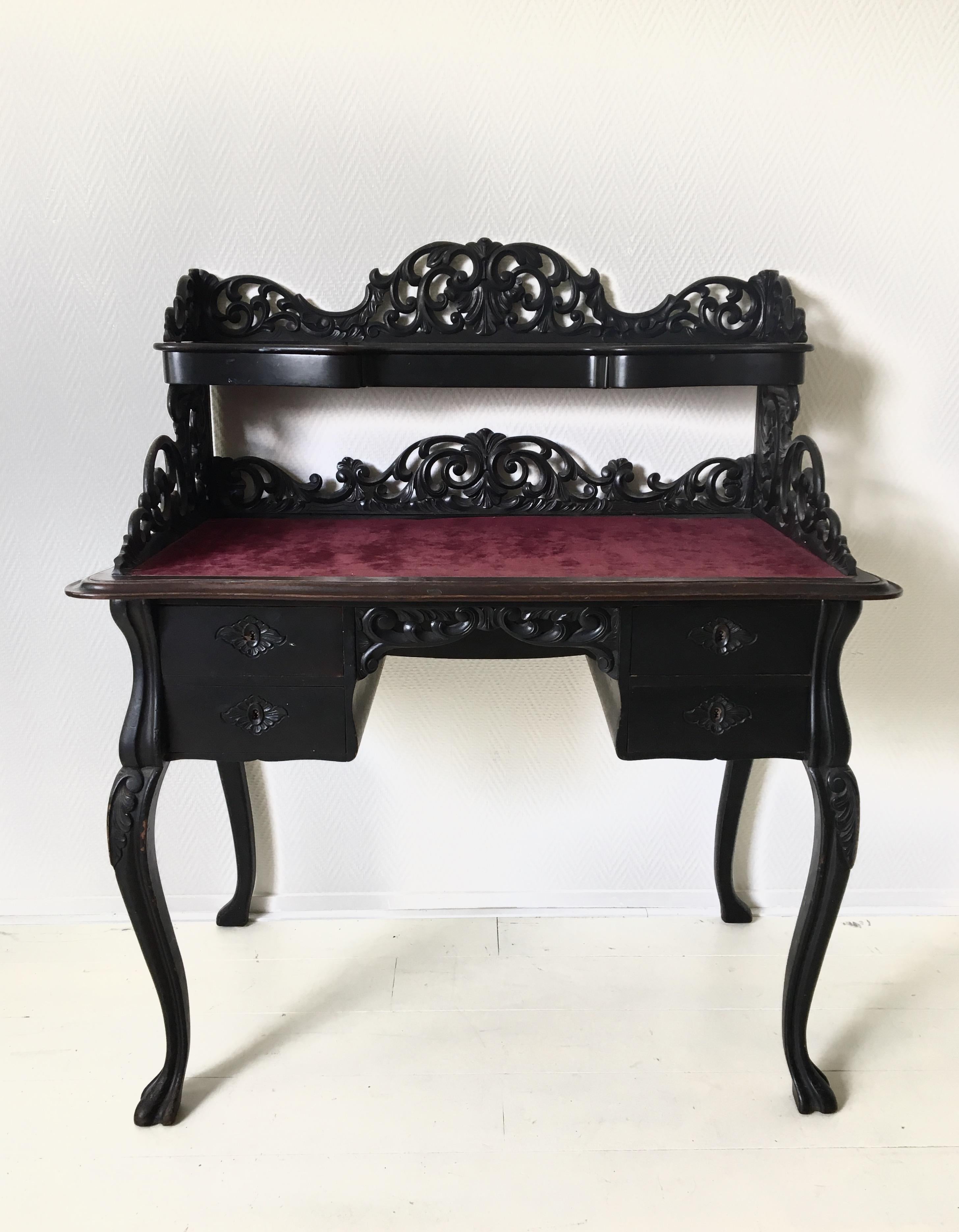 Beautiful Ebonized desk, with deep red velvet like writing area. The piece features in total six drawers, four in the lower part and three small hidden in the upper part of the desk. Very nice carvings (upper carving, height 11 cm, can be removed)