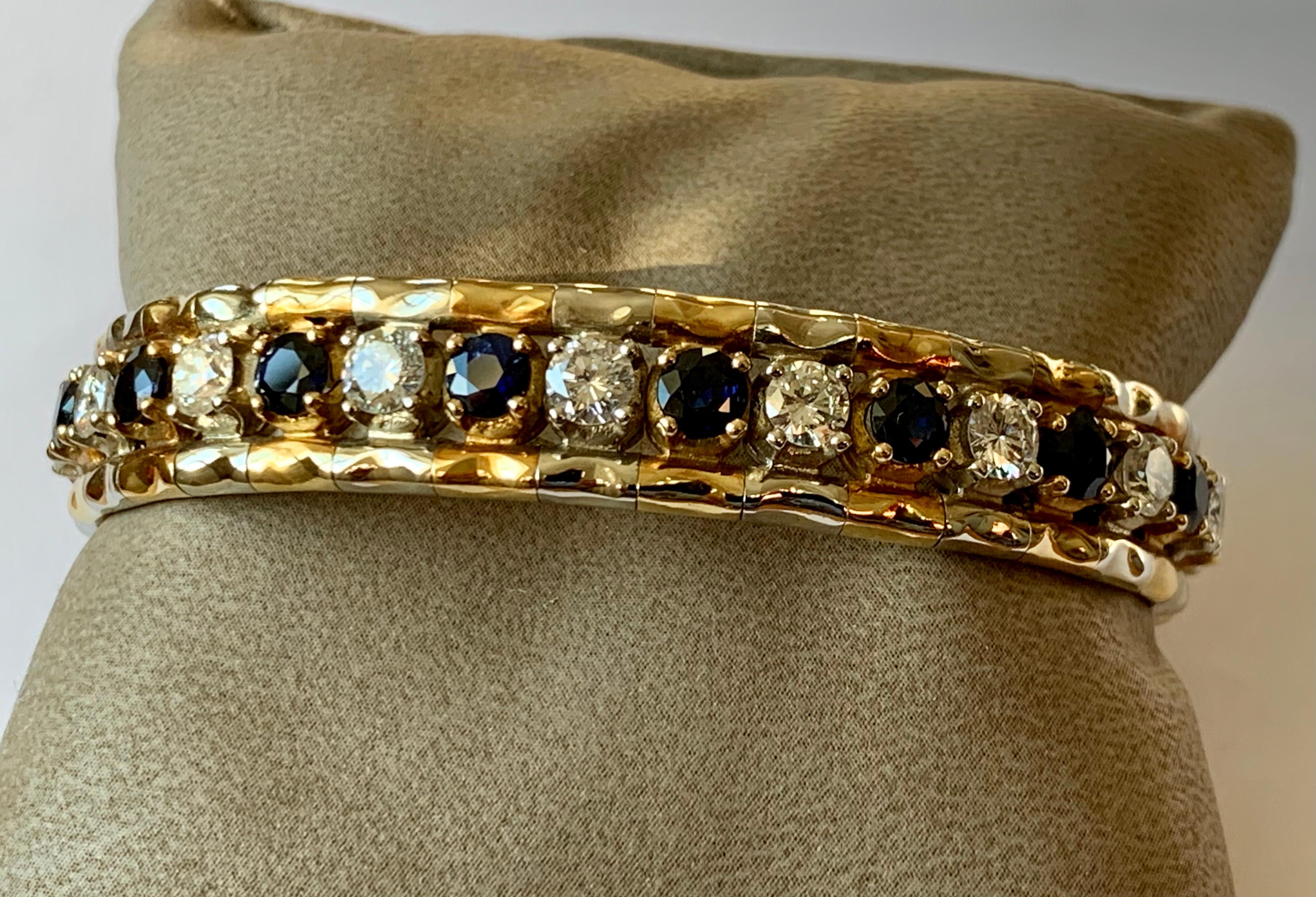 A beautiful 18 Karat yellow  and white Gold bangle bracelet featuring high quality diamonds and rich royal blue sapphires. 16 brilliant cut Diamonds weighing approximately 4.10 ct, G color, vs clarity and 16 Sapphires weighing approximately 4.30