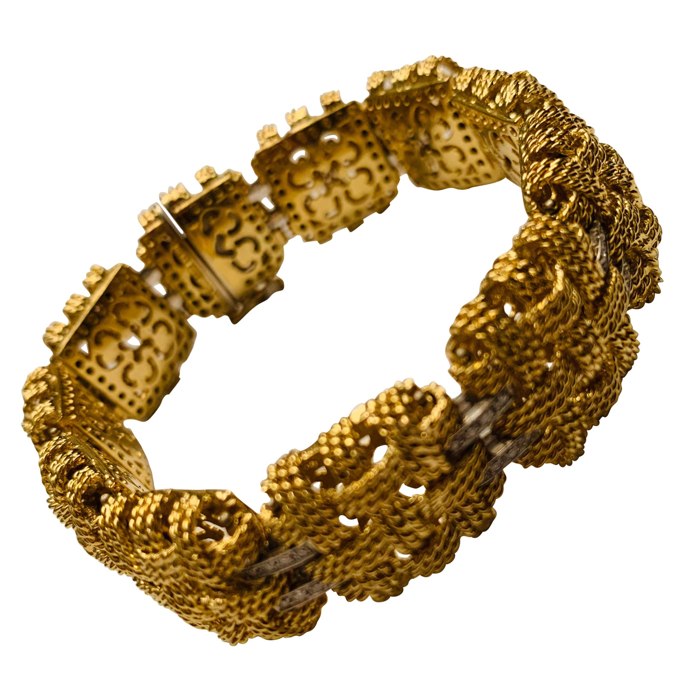 Ce large bracelet articulé est composé de motifs carrés avec un travail complexe de fil d'or. Chaque motif est relié à l'autre par des charnières qui sont pavées de 88 diamants d'un poids total de 1,40 ct. qui facilitent l'articulation. Longueur :
