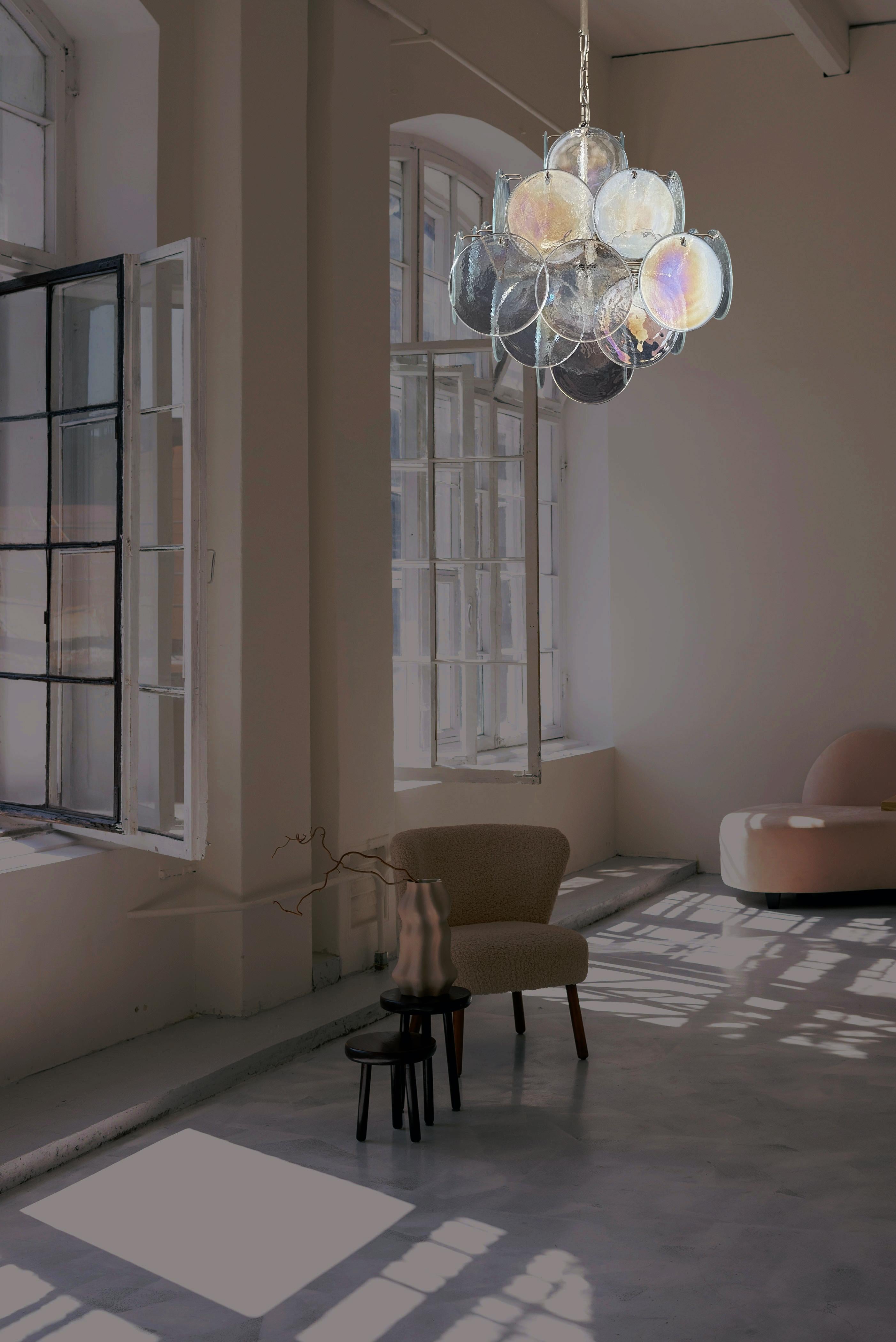 Lampadario italiano vintage di Murano in stile Vistosi. Il lampadario ha 36 fantastici dischi iridescenti in una struttura metallica in nichel. I vetri hanno la particolarità di riflettere una molteplicità di colori, il che rende il lampadario una