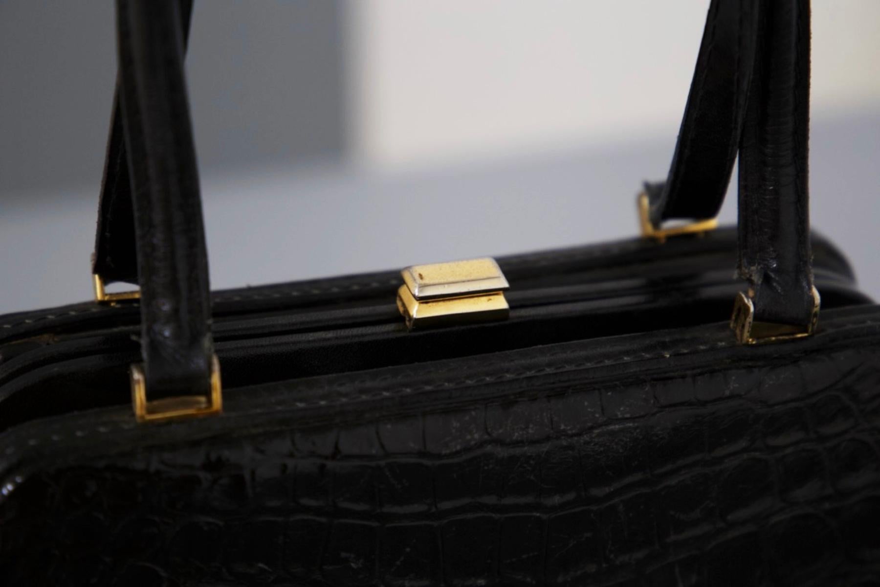 Wunderschöne schwarze Ledertasche, entworfen in den 1980er Jahren, italienische Herstellung.
Die Tasche hat eine rechteckige Form und ist ganz aus Leder, mit glänzender Krokodilstruktur, sehr sinnlich und elegant.
Die Handtasche hat die interne