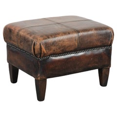 Eleganza del pouf in pelle di pecora vintage, con colori bellissimi e dettagli di grande valore Eleganza del pouf in pelle di pecora vintage, con colori bellissimi e dettagli di grande valore