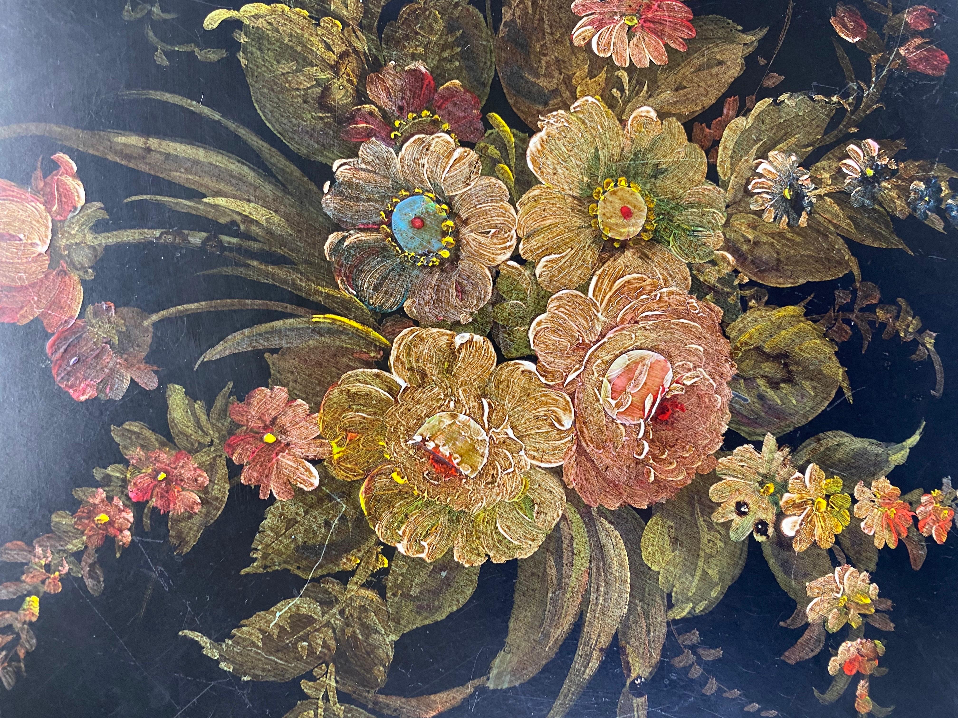 This is a vintage hand painted tilt top accent table. This tilt top table has a beautiful hand painted floral motif to the top of the table with a painted edge. The elegant scrolling legs have a gold painted floral Latif on the outer edge of the
