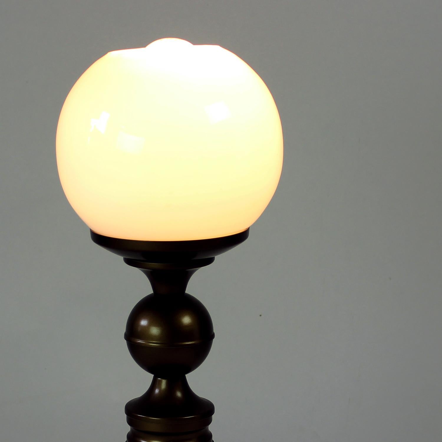 Beautiful and elegant table lamps produced by Drokov Brno in 1950s. The lamp is made of metal base in golden coloured finish. It is topped with a white opaline glass ball shield. The shield is not an original shield, nonethe less it fits the
