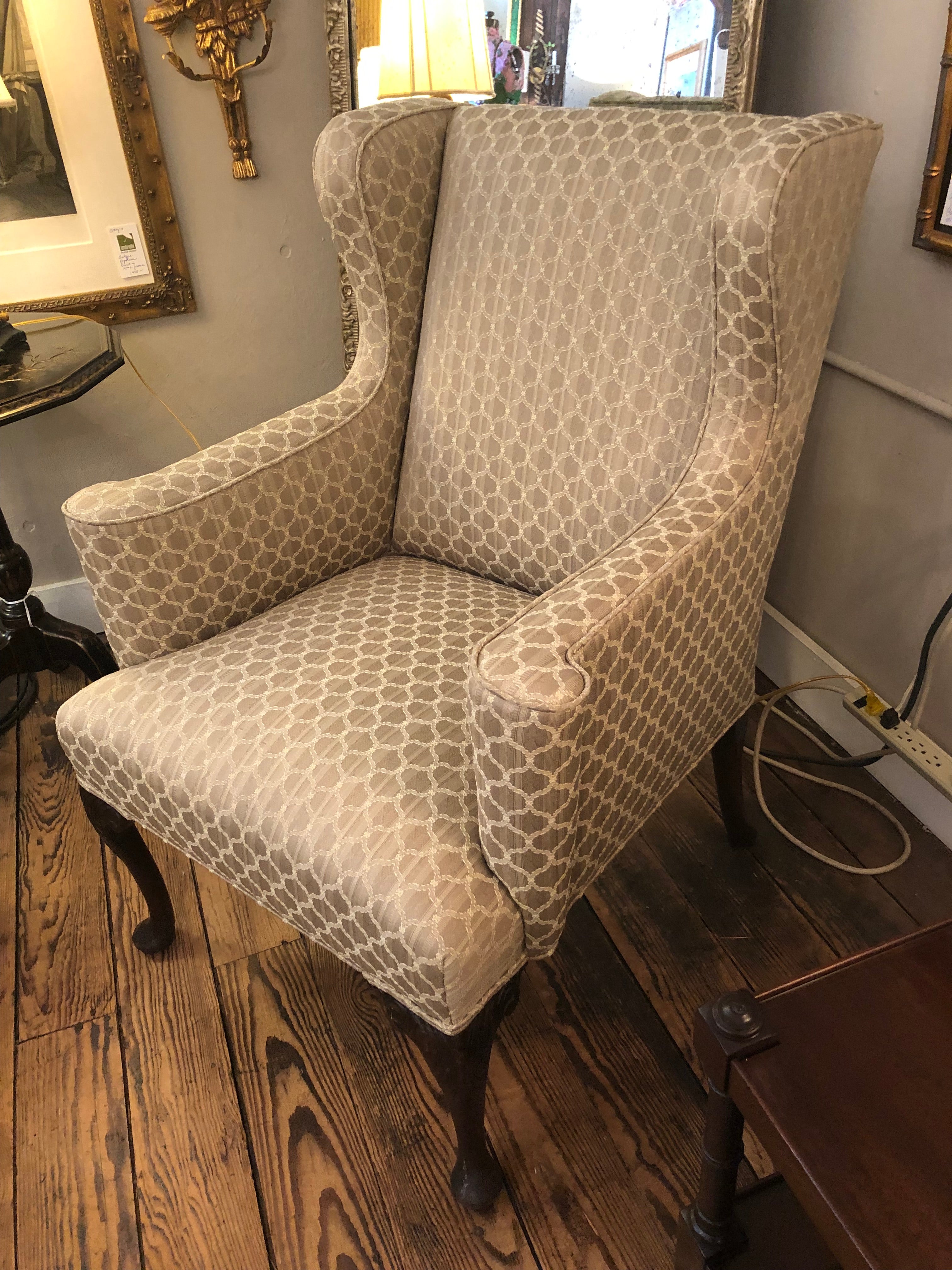 Classic wingback upholstered chair having neutral beige patterned fabric and beautiful carved walnut feet.
29.75 w arm to arm
26 w at the seat and top
arm height 27.