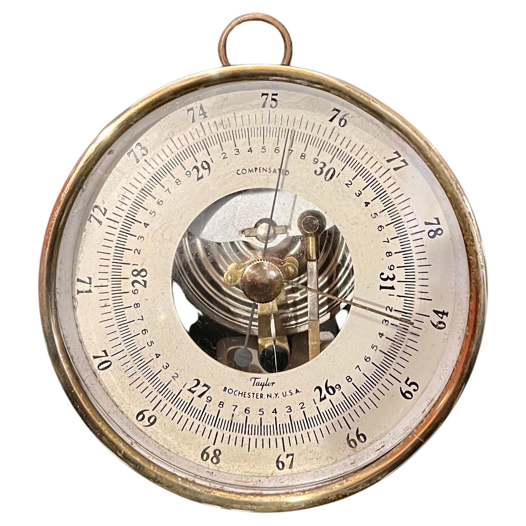 The beautiful design on this wall barometer by Taylor in patinated brass and glass can be hung on the wall or table top.
