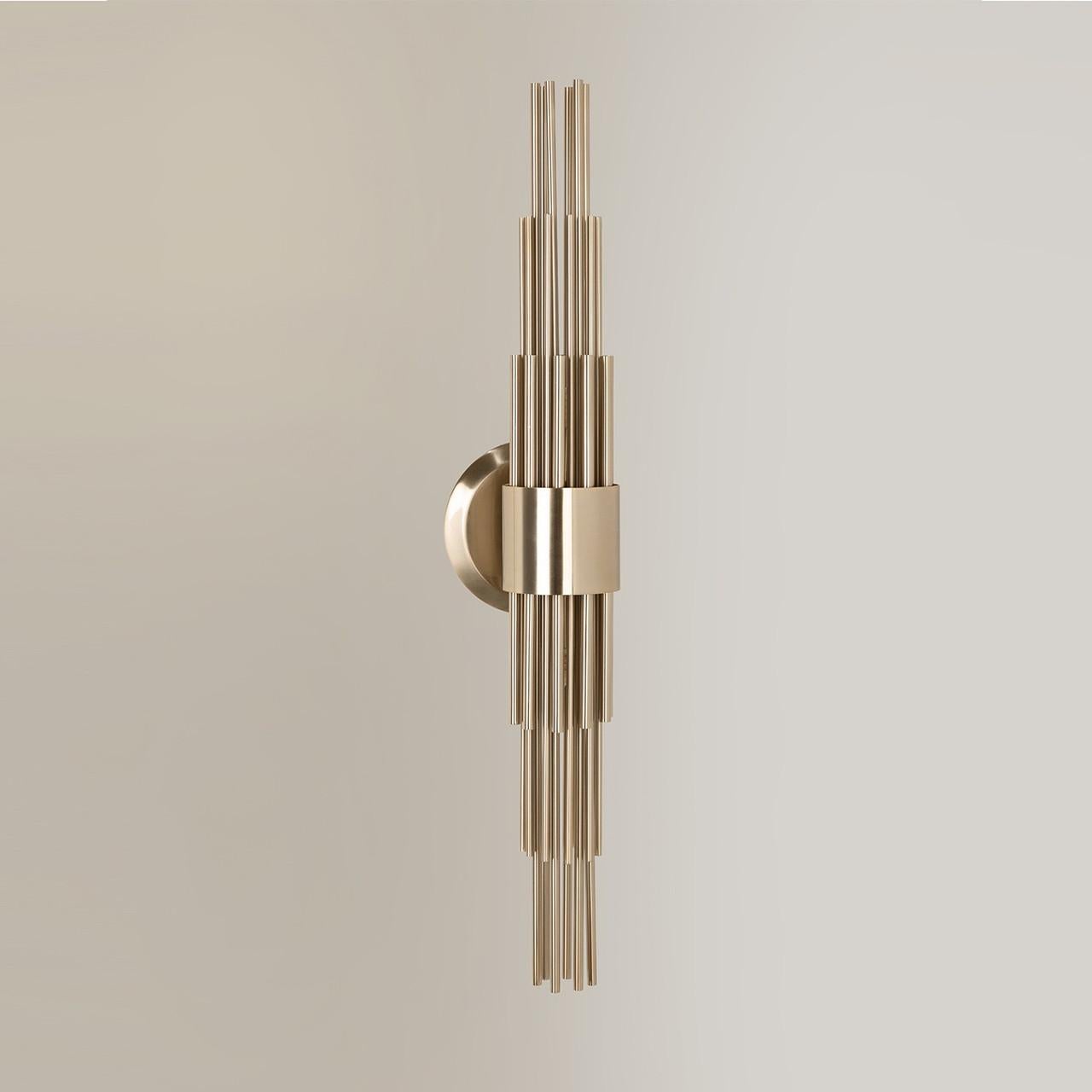 This elegant wall light features long gold plated brass tubes that give the design a whole exclusive and deluxe look, setting another level by its distinctive appearance. This recipe of rich materials and sleek lines inspired by art-deco