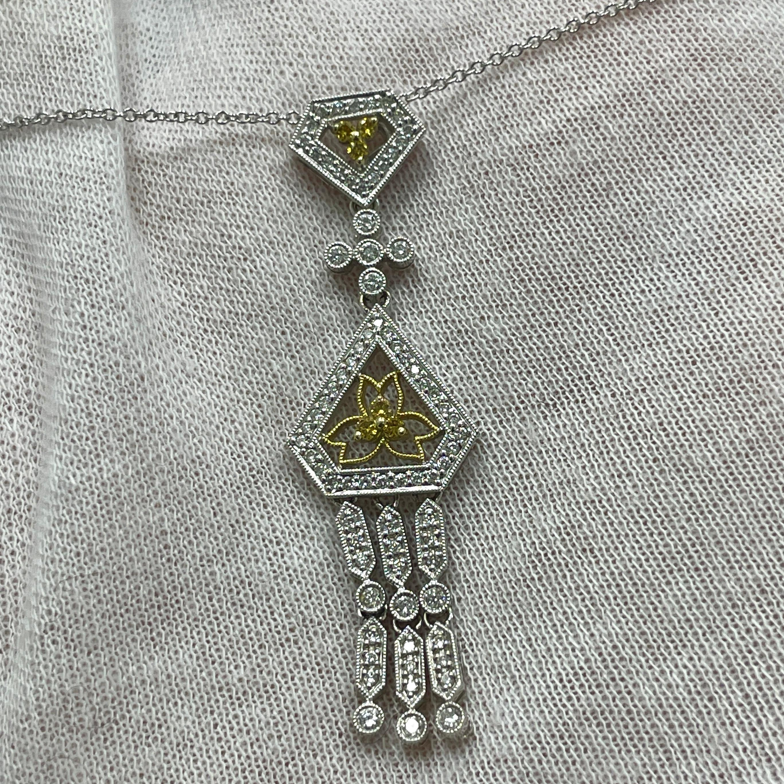 An intricately designed pendant with 0.55Ct of white diamonds, .08Ct of yellow diamonds set in 18K white gold. 