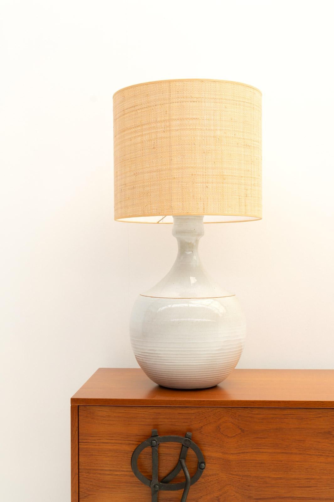 Discover the charm of this exquisite white ceramic table lamp, crafted in France in the late 70s and paired with a newly lampshade handmade in Belgium.

The lamp's graceful feminine silhouette adds a cozy and warm ambiance to any room, complementing