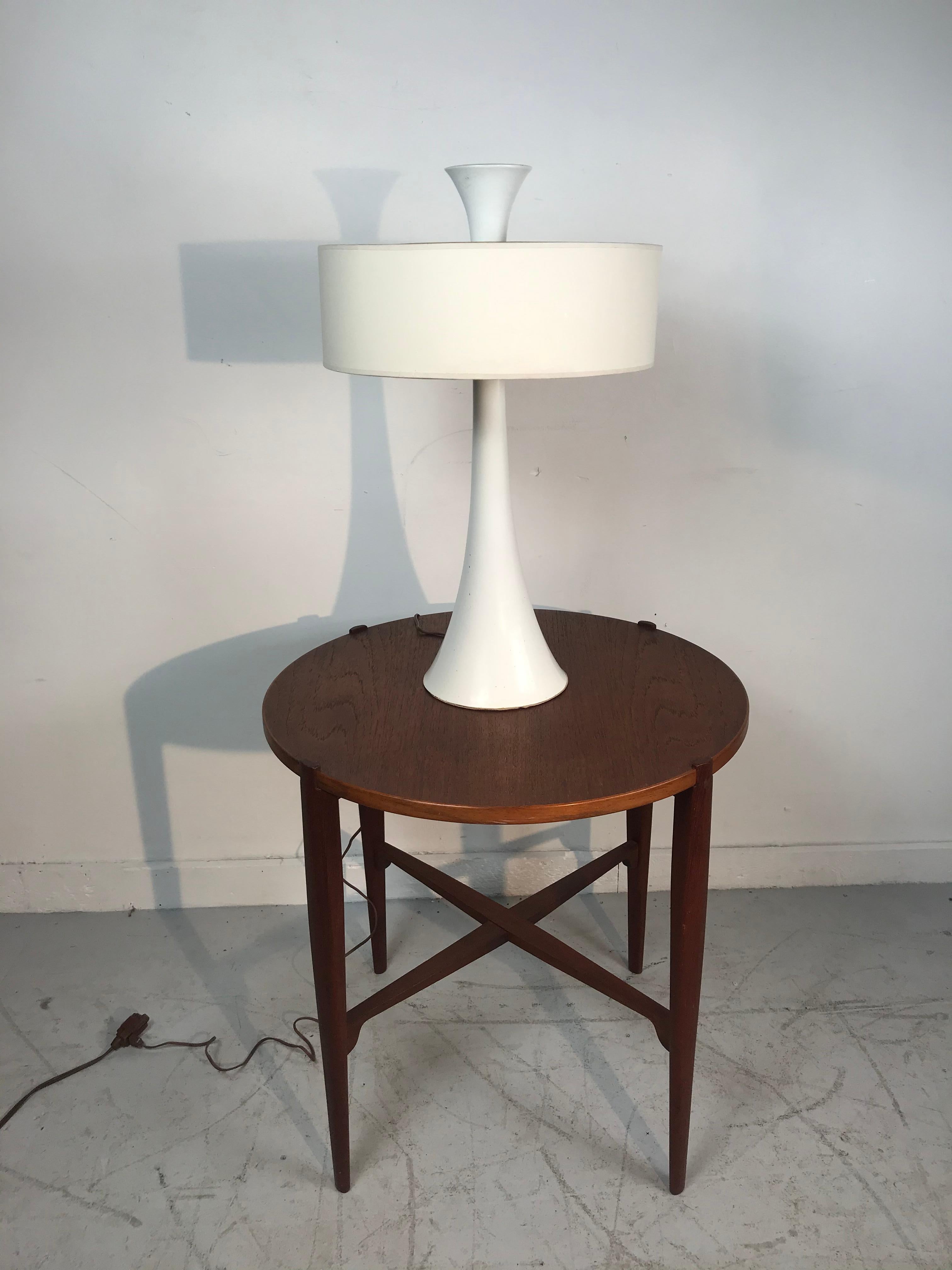 Elegant white modernist trumpet base table lamp attributed to Gerald Thurston for Lightolier. Lacquered metal trumpet shape base with amazing oversized finial. Retains original white cylinder lamp shade (minor damage) and metal diffuser. Truly a